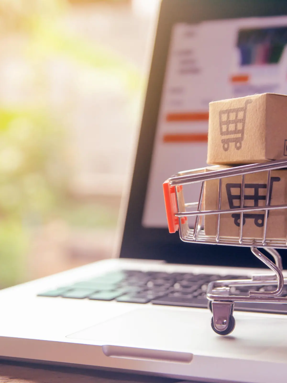 Shopping online concept - Parcel or Paper cartons with a shopping cart logo in a trolley on a laptop keyboard. Shopping service on The online web. offers home delivery.