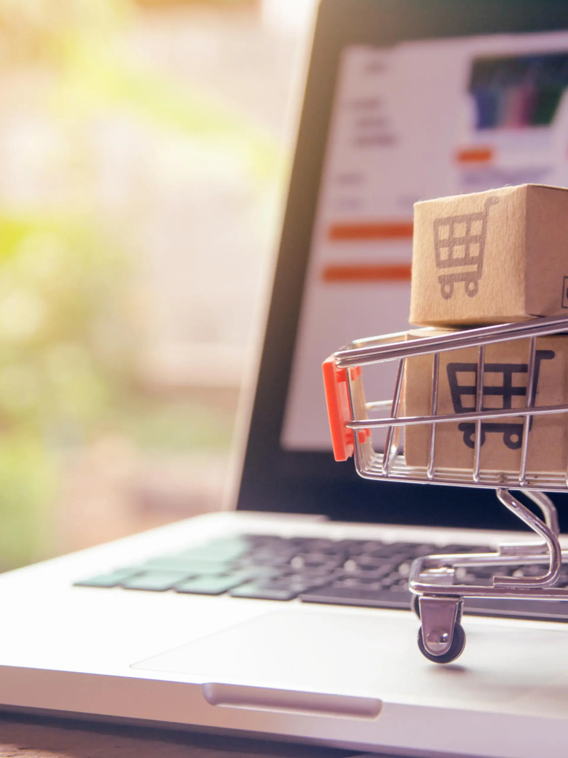 Shopping online concept - Parcel or Paper cartons with a shopping cart logo in a trolley on a laptop keyboard. Shopping service on The online web. offers home delivery.
