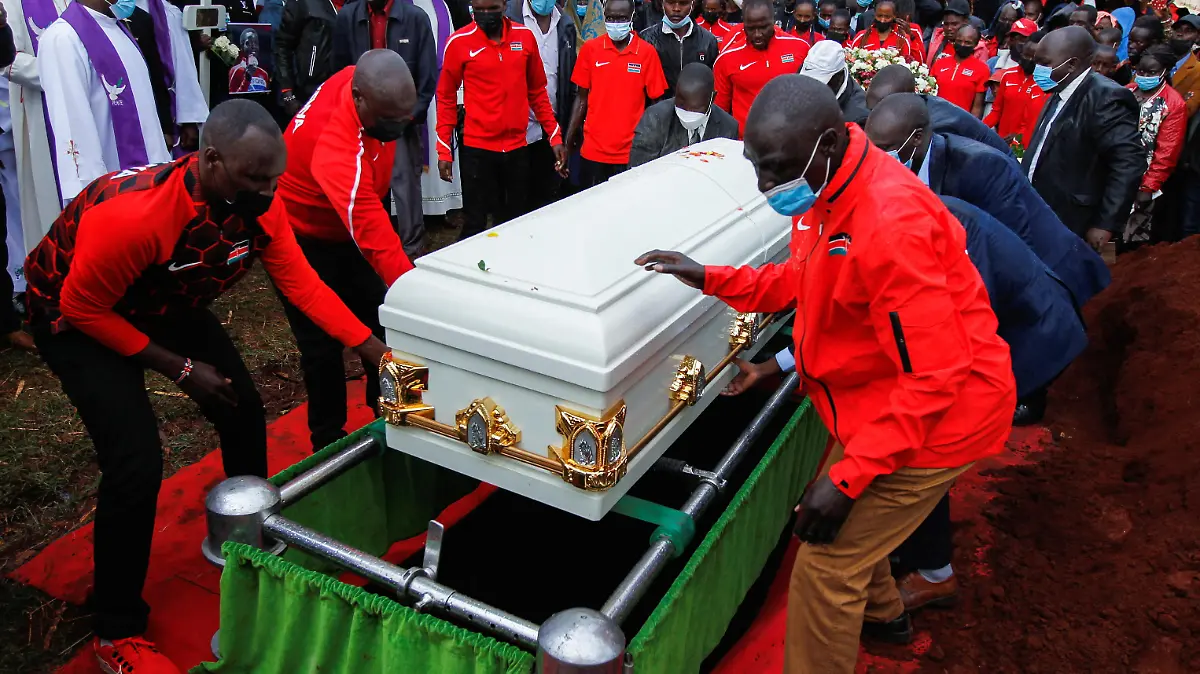 Kenyan athletes and family members place the coffin of the long-distance runner Agnes Tirop on her grave for burial at Kapnyamisa village, Nandi county, Kenya, October 23, 2021. REUTERS/Monicah Mwangi