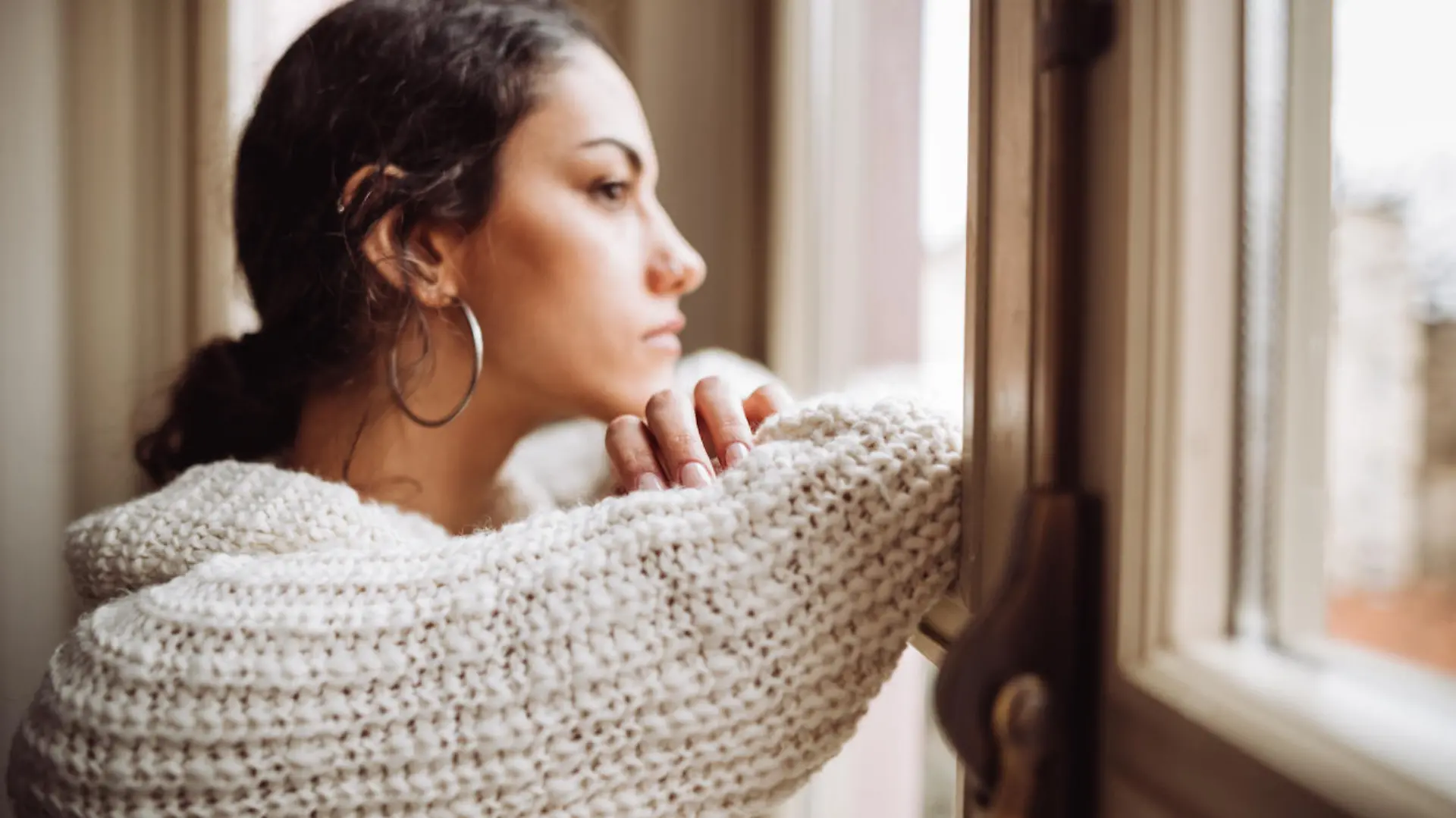 pensive woman in front of the window
