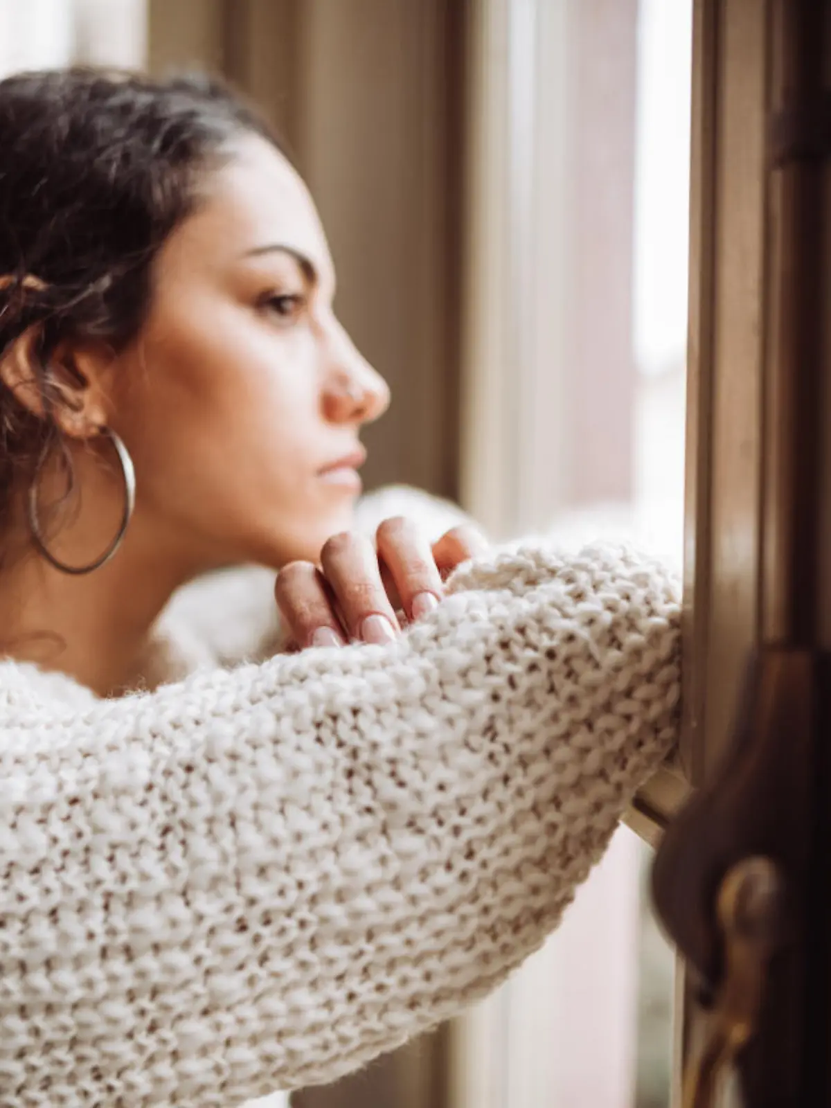 pensive woman in front of the window