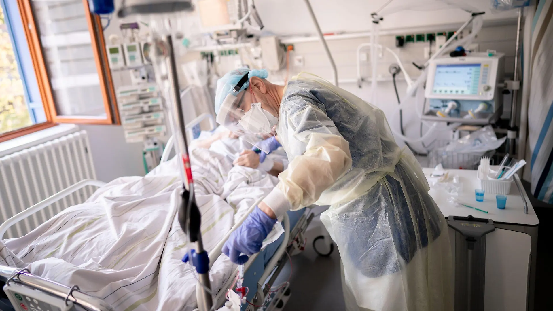 ARCHIV - 20.04.2021, Berlin: Ein Intensivpfleger arbeitet auf der Intensivstation eines Krankenhauses an einer an Covid-19 erkrankten Patientin. Die Gefahr einer Corona-Infektion ist für immer mehr Menschen in Deutschland im Verlauf der Pandemie nähergerückt. So haben im vergangenen März bereits sieben von zehn Menschen mindestens einen Menschen aus dem engeren Umfeld gekannt, der eine Coronainfektion erlitten hatte. (zu dpa "Corona-Gefahr rückte für die Menschen in Deutschland immer näher") Foto: Kay Nietfeld/dpa +++ dpa-Bildfunk +++