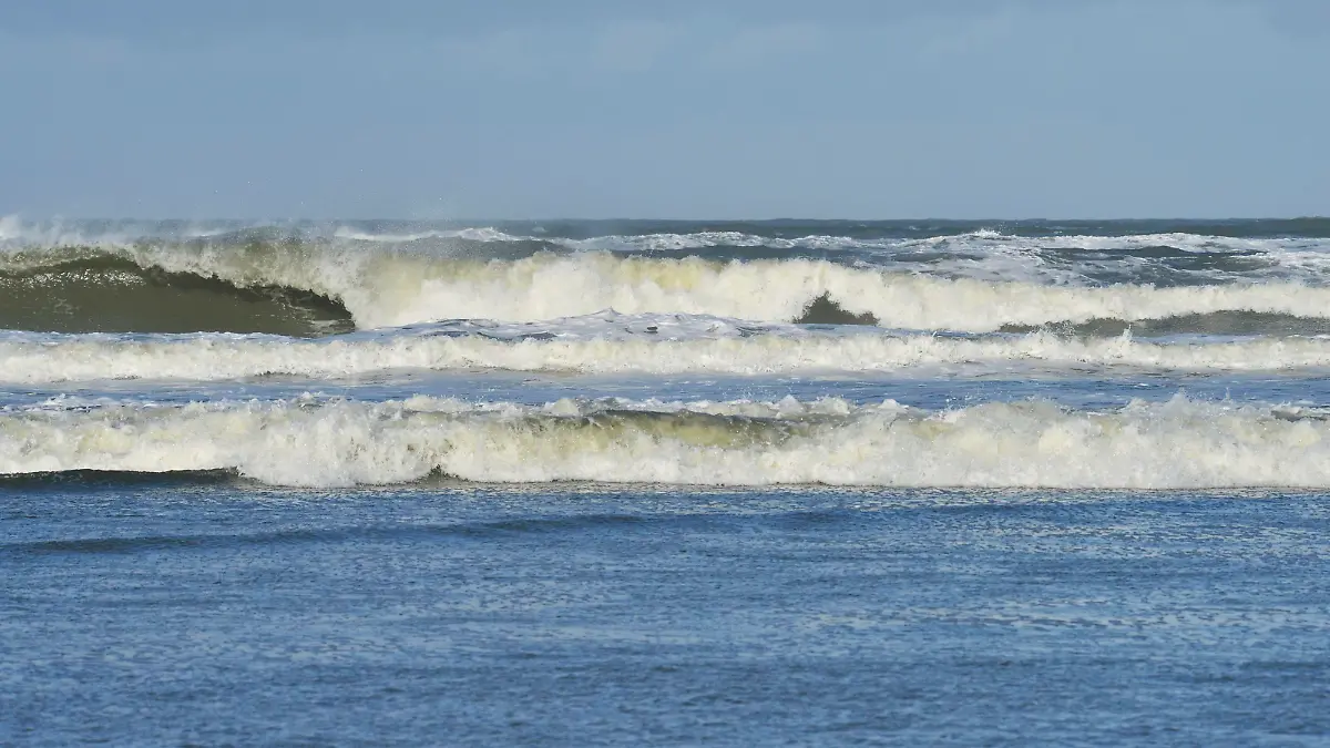 Wellen mit weißer Gischt von der stürmischen Nordsee an der Küste der Insel Langeoog, 24.10.2013
