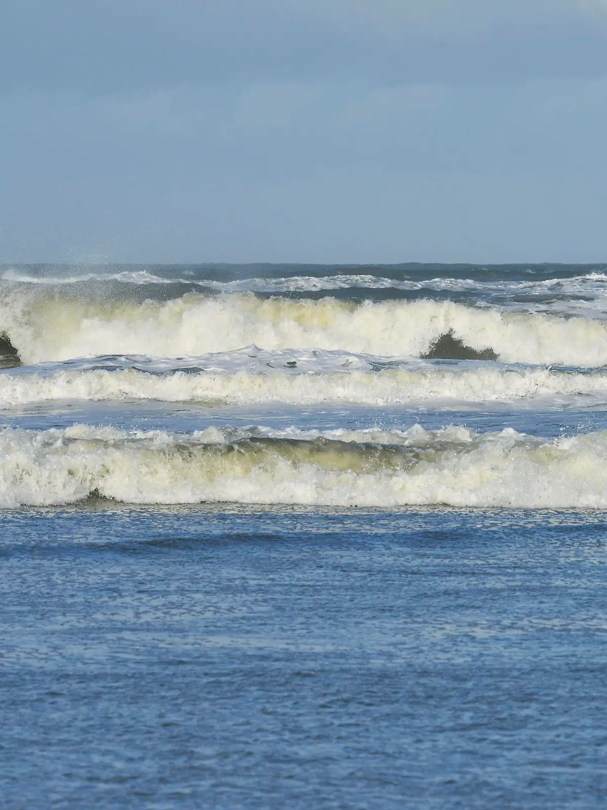 Wellen mit weißer Gischt von der stürmischen Nordsee an der Küste der Insel Langeoog, 24.10.2013