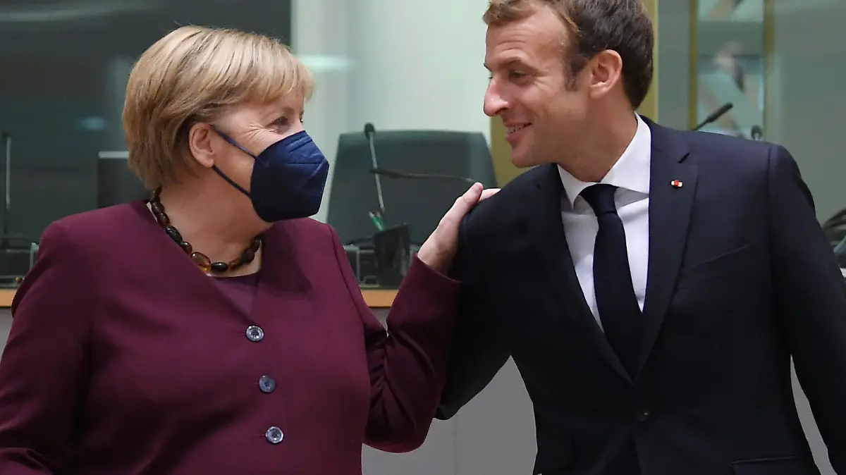 France's President Emmanuel Macron, right, talks to Germany's Chancellor Angela Merkel during a round table meeting at an EU summit in Brussels, Friday, Oct. 22, 2021. European Union leaders conclude a two-day summit on Friday in which they discussed issues such as climate change, the energy crisis, COVID-19 developments and migration. (John Thys, Pool Photo via AP)