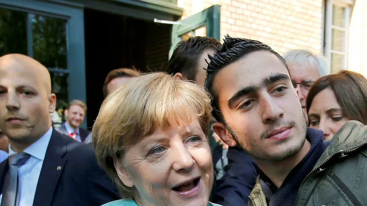FILE PHOTO: Syrian refugee Anas Modamani takes a selfie with German Chancellor Angela Merkel outside a refugee camp near the Federal Office for Migration and Refugees after registration at Berlin's Spandau district, Germany September 10, 2015.      REUTERS/Fabrizio Bensch/File Photo