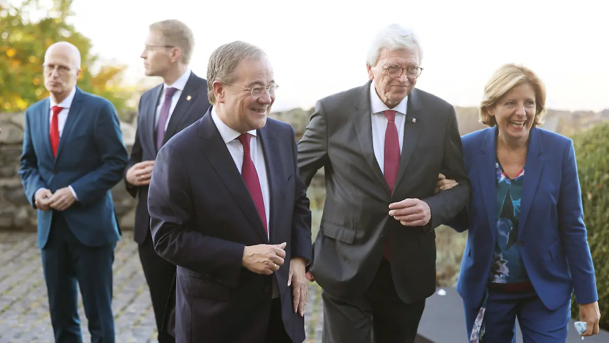22.10.2021, Nordrhein-Westfalen, Königswinter: Die Ministerpräsidenten Malu Dreyer (r, SPD, Rheinland-Pfalz), Volker Bouffier (2.v.r, CDU, Hessen) und Armin Laschet (3.v.r, CDU, Nordrhein-Westfalen) gehen zum Gruppenfoto, während im Hintergrund Peter Tschentscher (l, SPD, Hamburg) und Daniel Günther (2.v.l, CDU, Schleswig-Holstein) zusammenstehen. Zu den Hauptthemen der Konferenz der Ministerpräsidenten zählt der Umgang mit der Pandemie. Foto: Oliver Berg/dpa-Pool/dpa +++ dpa-Bildfunk +++