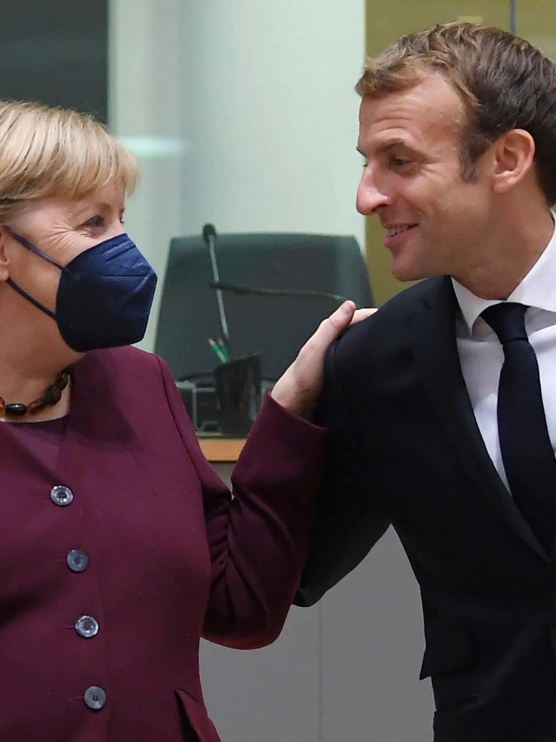 France's President Emmanuel Macron, right, talks to Germany's Chancellor Angela Merkel during a round table meeting at an EU summit in Brussels, Friday, Oct. 22, 2021. European Union leaders conclude a two-day summit on Friday in which they discussed issues such as climate change, the energy crisis, COVID-19 developments and migration. (John Thys, Pool Photo via AP)