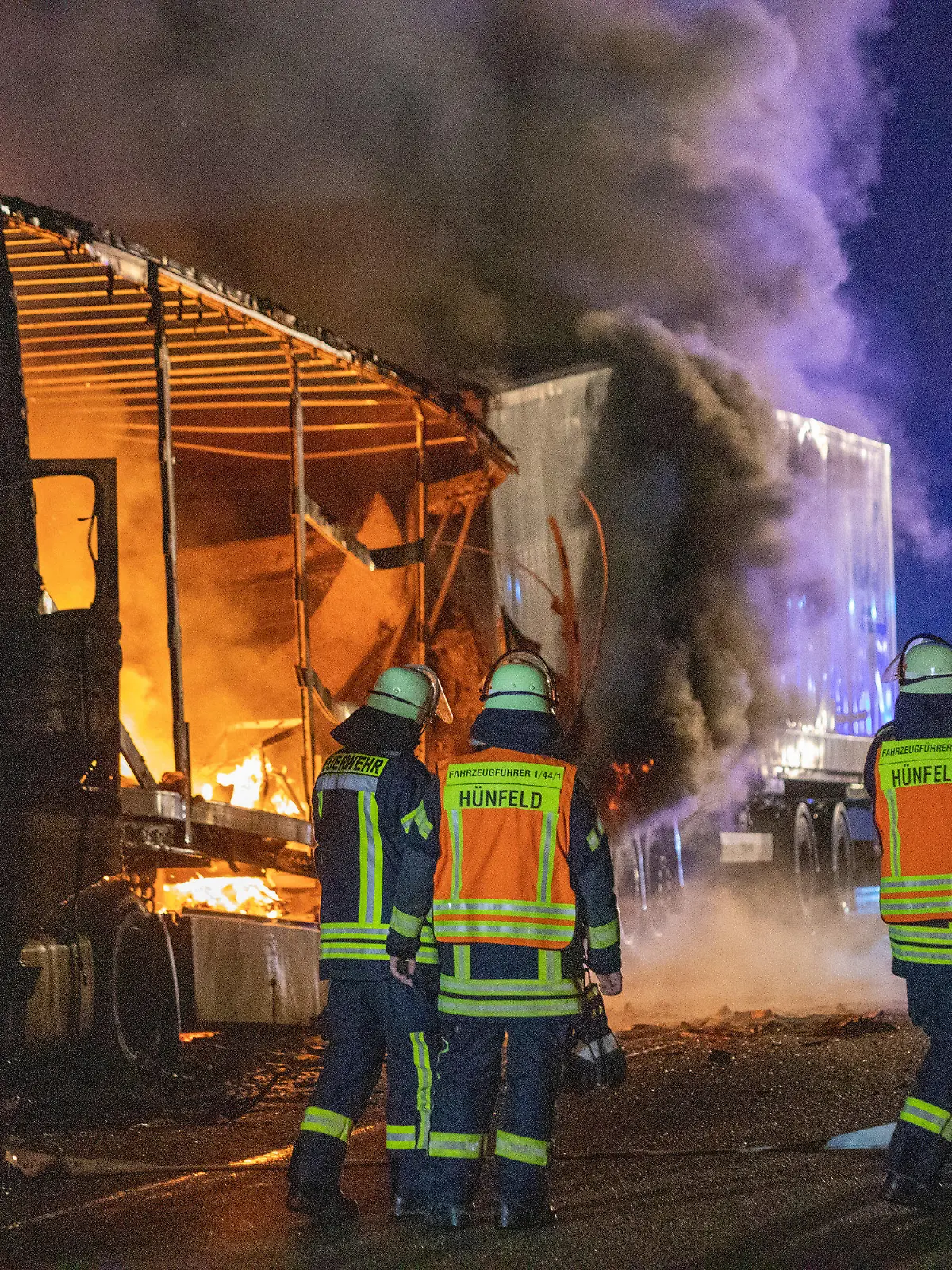 21.10.2021, Hessen, Burghaun: Einsatzkräfte der Feuerwehr stehen neben brennenden Lastkraftwagen, die bei einem Unfall aufeinander gefahren sind. Foto: Fuldamedia/dpa +++ dpa-Bildfunk +++