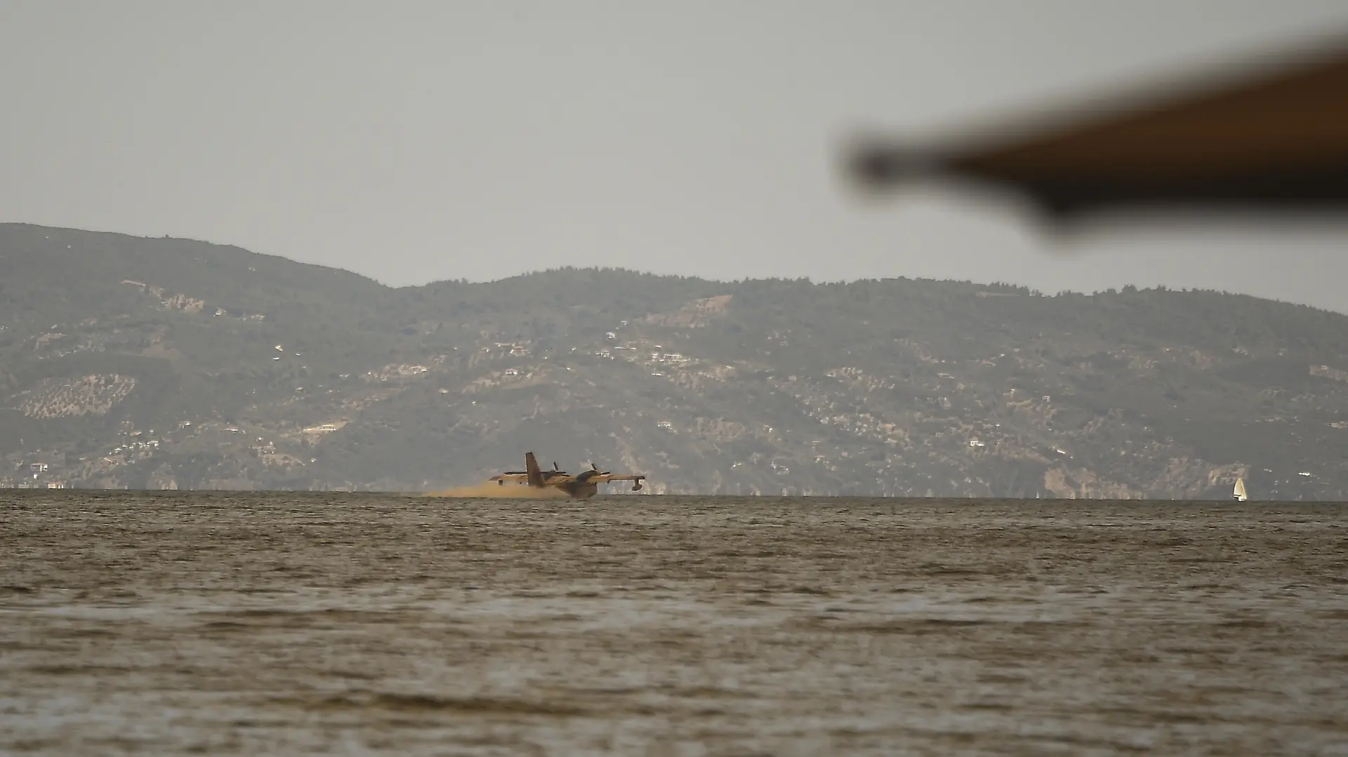 EVIA, GREECE - AUGUST 08: An aircraft refuel with water from the sea to battle against the fire in the Gouves village, on the island of Evia on the fifth day of a wildfire in the area north of the island of Evia, Greece on August 8, 2021. Dimitris Lampropoulos / Anadolu Agency
