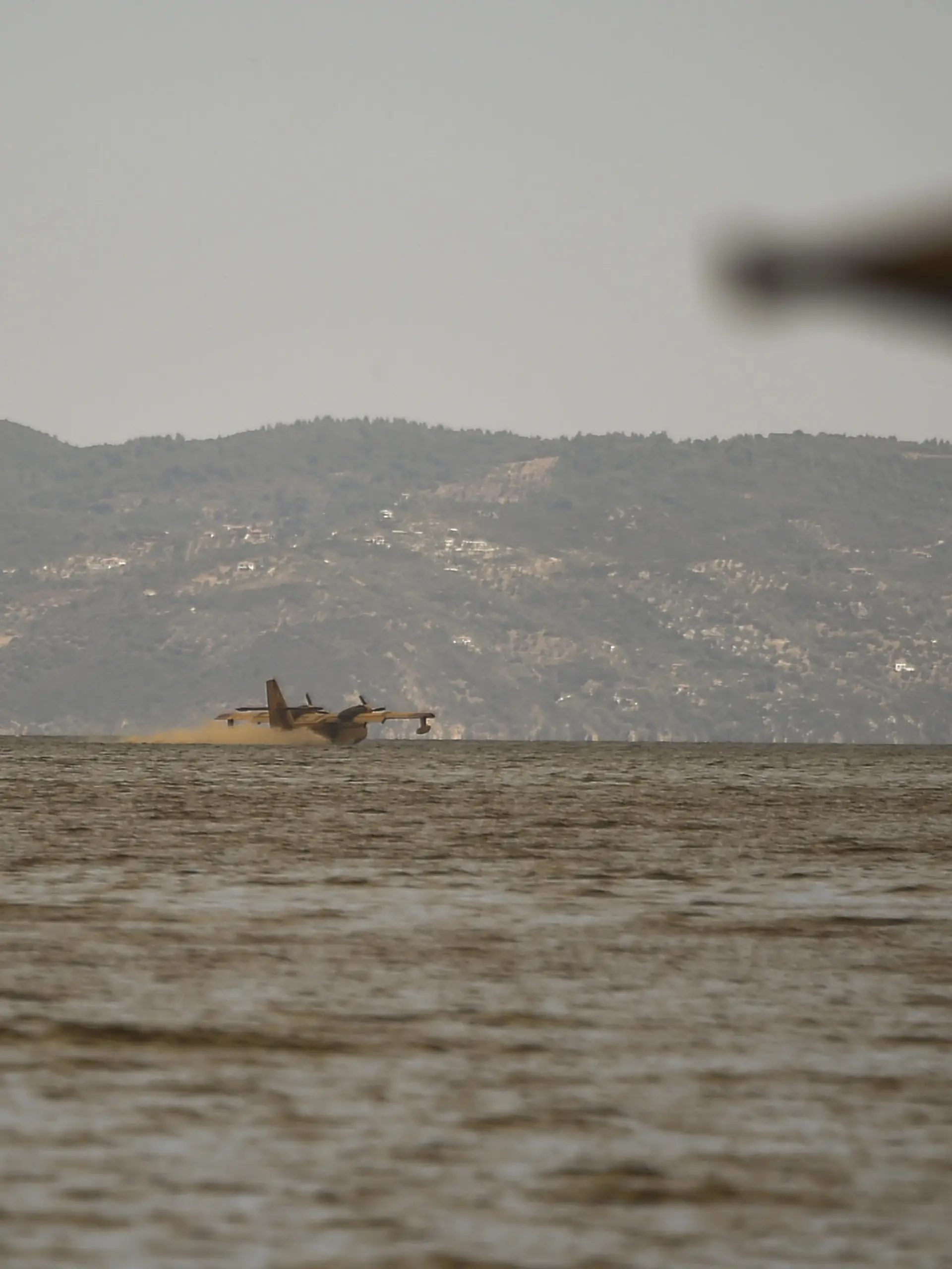 EVIA, GREECE - AUGUST 08: An aircraft refuel with water from the sea to battle against the fire in the Gouves village, on the island of Evia on the fifth day of a wildfire in the area north of the island of Evia, Greece on August 8, 2021. Dimitris Lampropoulos / Anadolu Agency