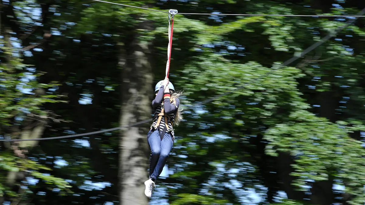 Eine Schülerin fährt am Mittwoch (16.06.2010) im Waldklettergarten Kloster Banz bei Bad Staffelstein (Oberfranken) eine Seilrutsche entlang. Während weite Teile Bayerns am Mittwoch unter einer Wolkendecke lagen, schien vor allem in Ober- und Unterfranken bei knapp 20 Grad Celsius meist die Sonne. David Ebener dpa/lby +++ dpa-Bildfunk +++