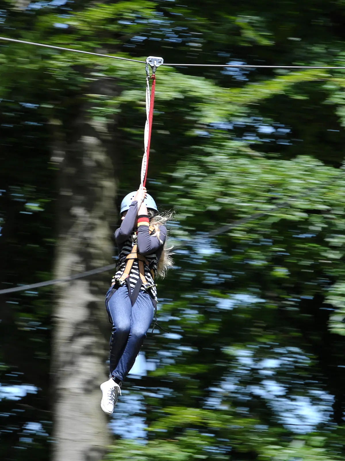 Eine Schülerin fährt am Mittwoch (16.06.2010) im Waldklettergarten Kloster Banz bei Bad Staffelstein (Oberfranken) eine Seilrutsche entlang. Während weite Teile Bayerns am Mittwoch unter einer Wolkendecke lagen, schien vor allem in Ober- und Unterfranken bei knapp 20 Grad Celsius meist die Sonne. David Ebener dpa/lby +++ dpa-Bildfunk +++