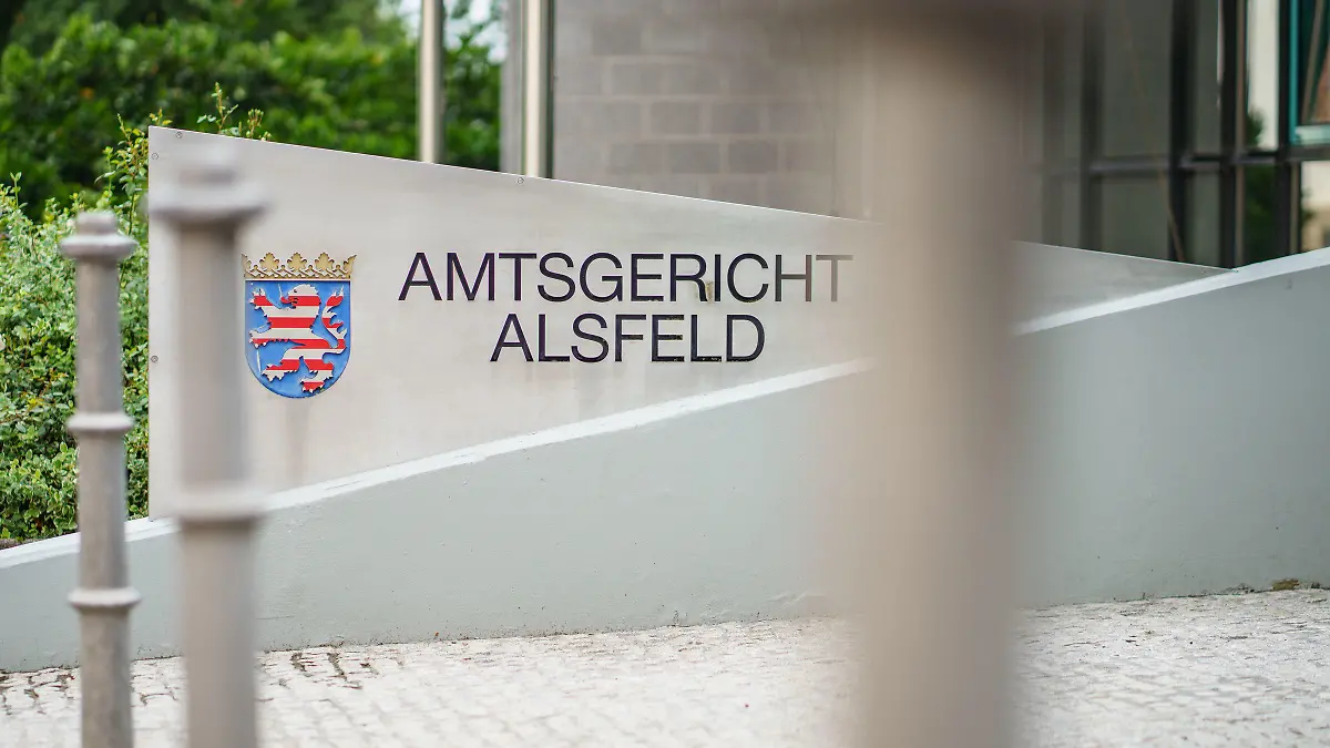 29.06.2021, Hessen, Alsfeld: "Amtsgericht Alsfeld" steht am Morgen vor Beginn eines Prozesses gegen einen 46-jährigen Polizeibeamten vor dem Eingangbereich. Dem 46-Jährigen wird zur Last gelegt, Ende 2018 "strafrechtlich relevante Inhalte" in WhatsApp-Gruppen versendet und damit auch eine mögliche Weiterverbreitung in Kauf genommen zu haben. Der Mann, der zuletzt im Polizeipräsidium Westhessen tätig war, war vom Dienst suspendiert worden. Foto: Frank Rumpenhorst/dpa +++ dpa-Bildfunk +++