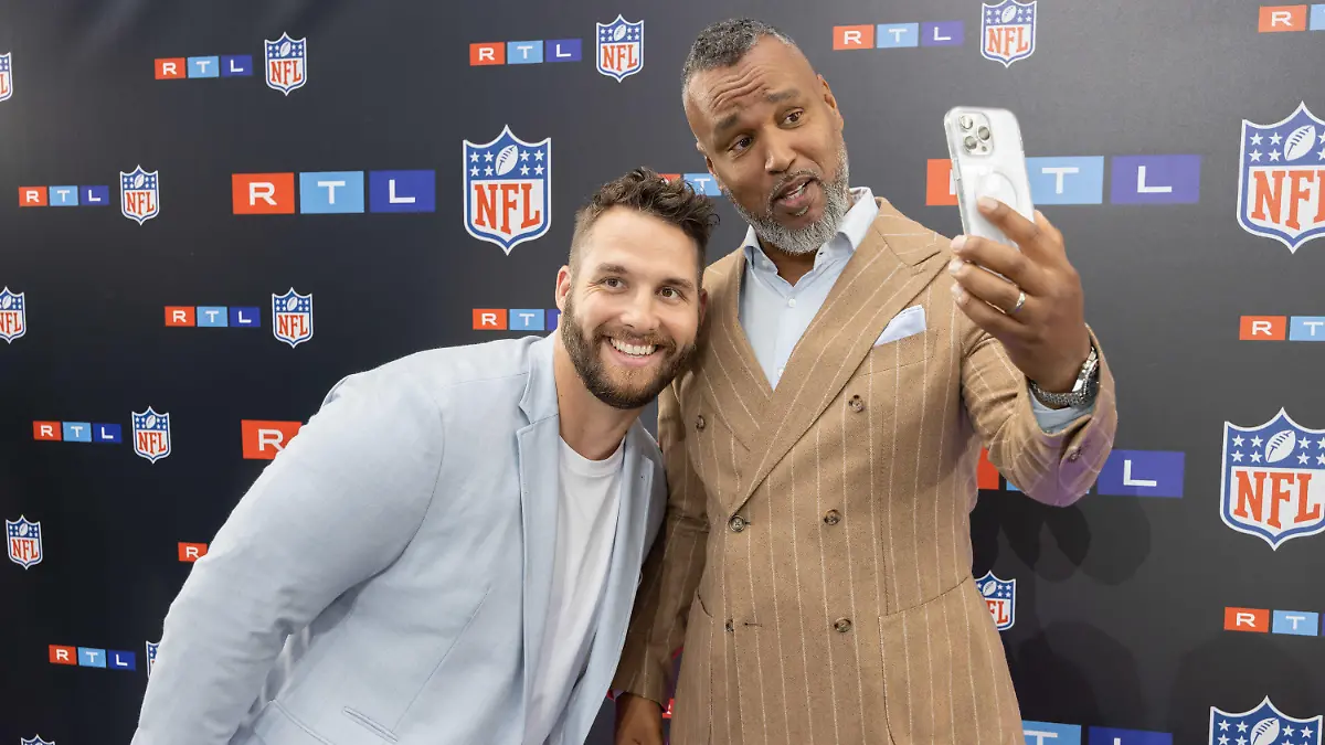 26.05.2023, Hessen, Frankfurt am Main: TV-Experte und Commissioner der European League of Football, Patrick Esume (r) und der TV-Experte und ehemaliger NFL-Spieler Björn Werner stehen an der Logowand. Beide präsentieren gemeinsam den Podcast "Football Bromance". Der neue Rechte-Inhaber RTL hat sein TV-Team und seine Planungen für die kommende NFL-Saison vorgestellt. Foto: Jürgen Kessler/dpa +++ dpa-Bildfunk +++