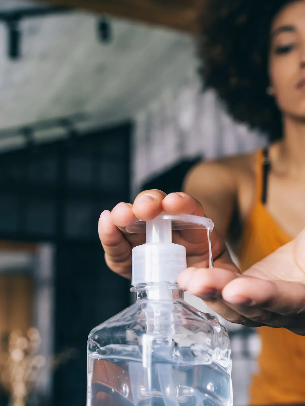 Afro woman applying hand sanitizer,during Covid-19
