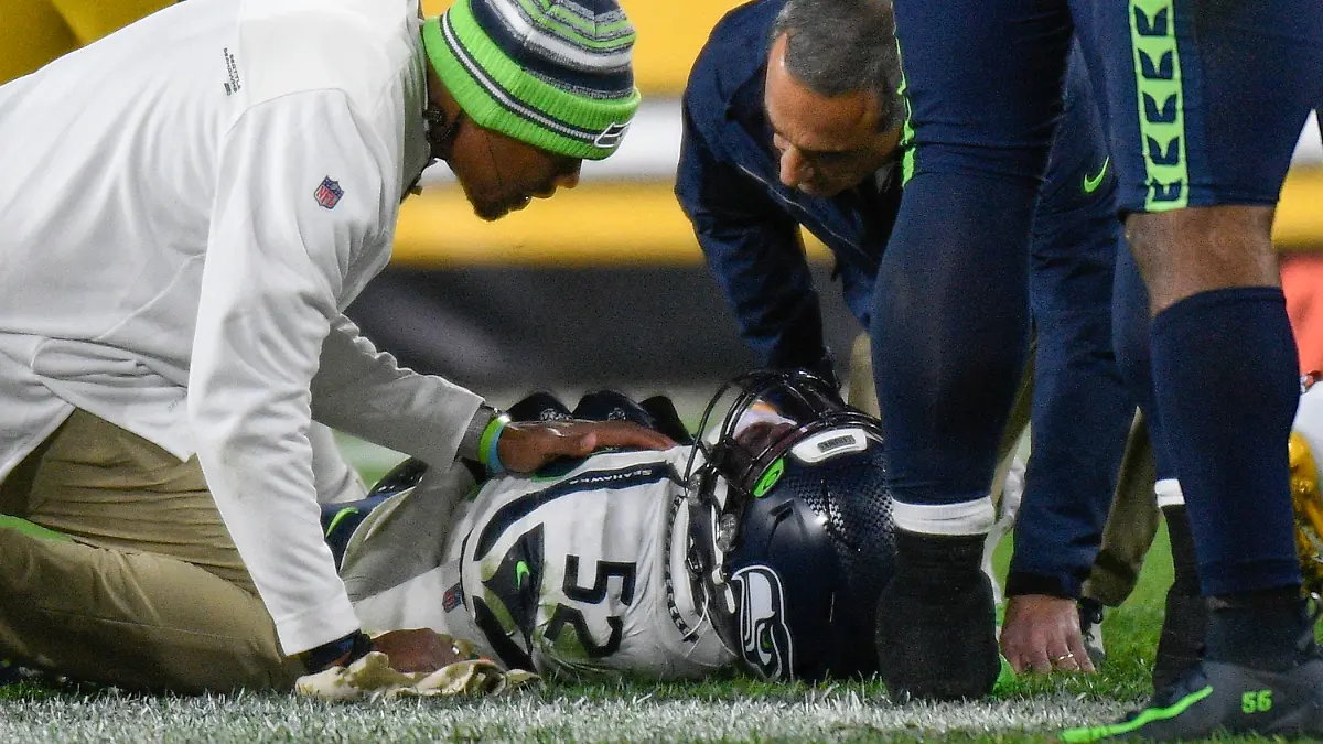 Seattle Seahawks defensive end Darrell Taylor (52) lays on the ground and is tended after being injured during the second half an NFL football game against the Pittsburgh Steelers, Sunday, Oct. 17, 2021, in Pittsburgh. (AP Photo/Don Wright)