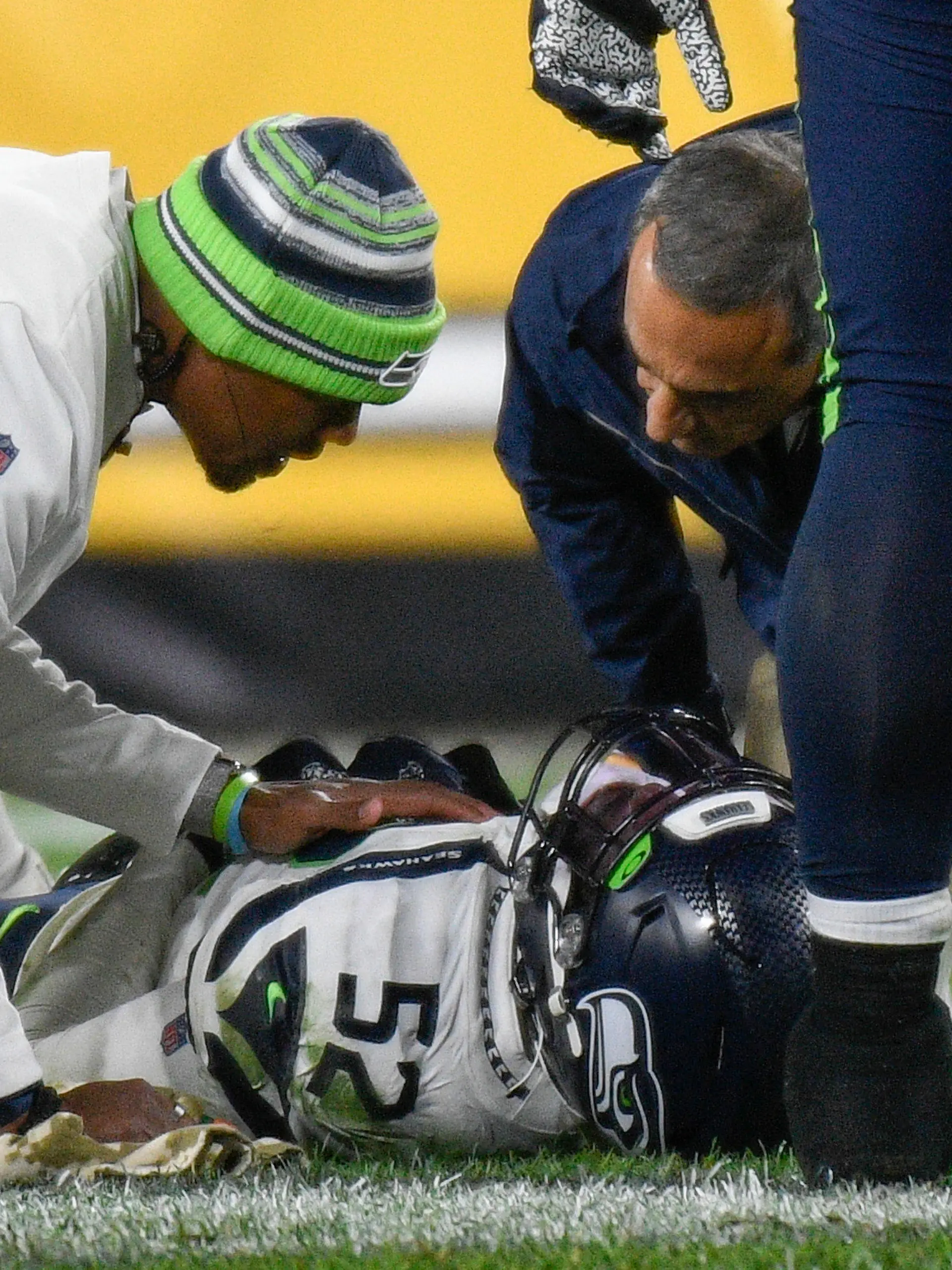 Seattle Seahawks defensive end Darrell Taylor (52) lays on the ground and is tended after being injured during the second half an NFL football game against the Pittsburgh Steelers, Sunday, Oct. 17, 2021, in Pittsburgh. (AP Photo/Don Wright)