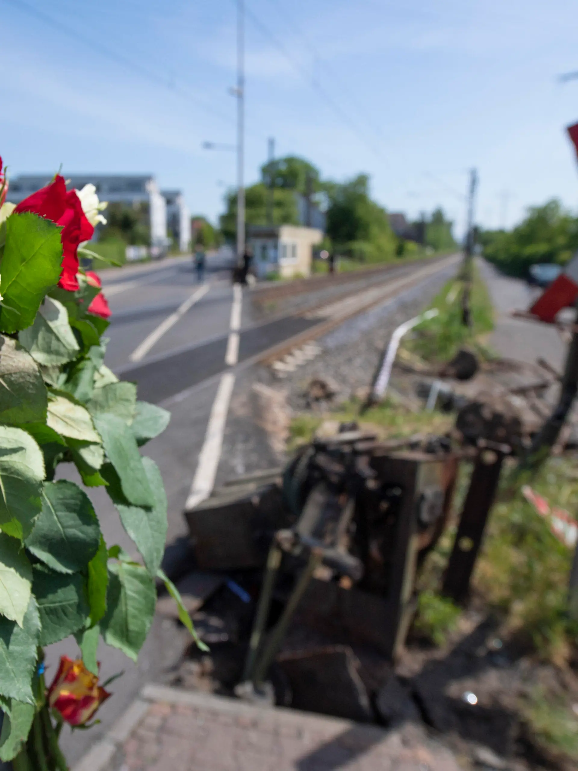 08.05.2020, Hessen, Frankfurt/Main: Blumen stecken am Unglücksort an einem Bahnübergang im Stadtteil Nied, wo am Vortag bei einem Unfall eine 16-Jährige tödlich verletzt worden war. Nach bisherigen Ermittlungen waren die Schranken zum Zeitpunkt des Unglücks nicht geschlossen. Foto: Boris Roessler/dpa +++ dpa-Bildfunk +++