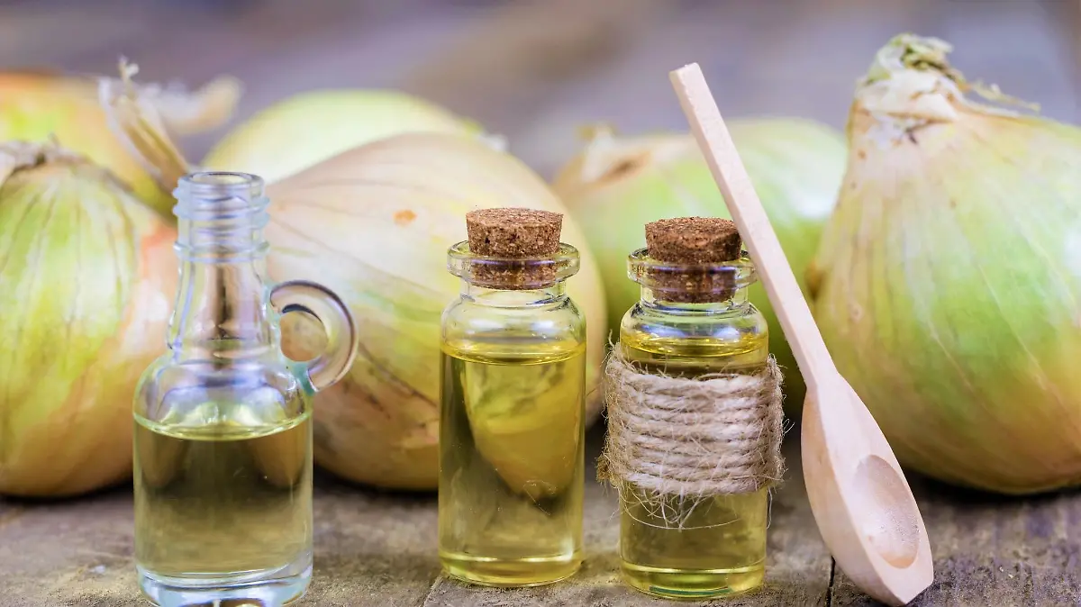 Onion juice and vegetables on a wooden table. Home-made syrup for the treatment of influenza. Dark background.