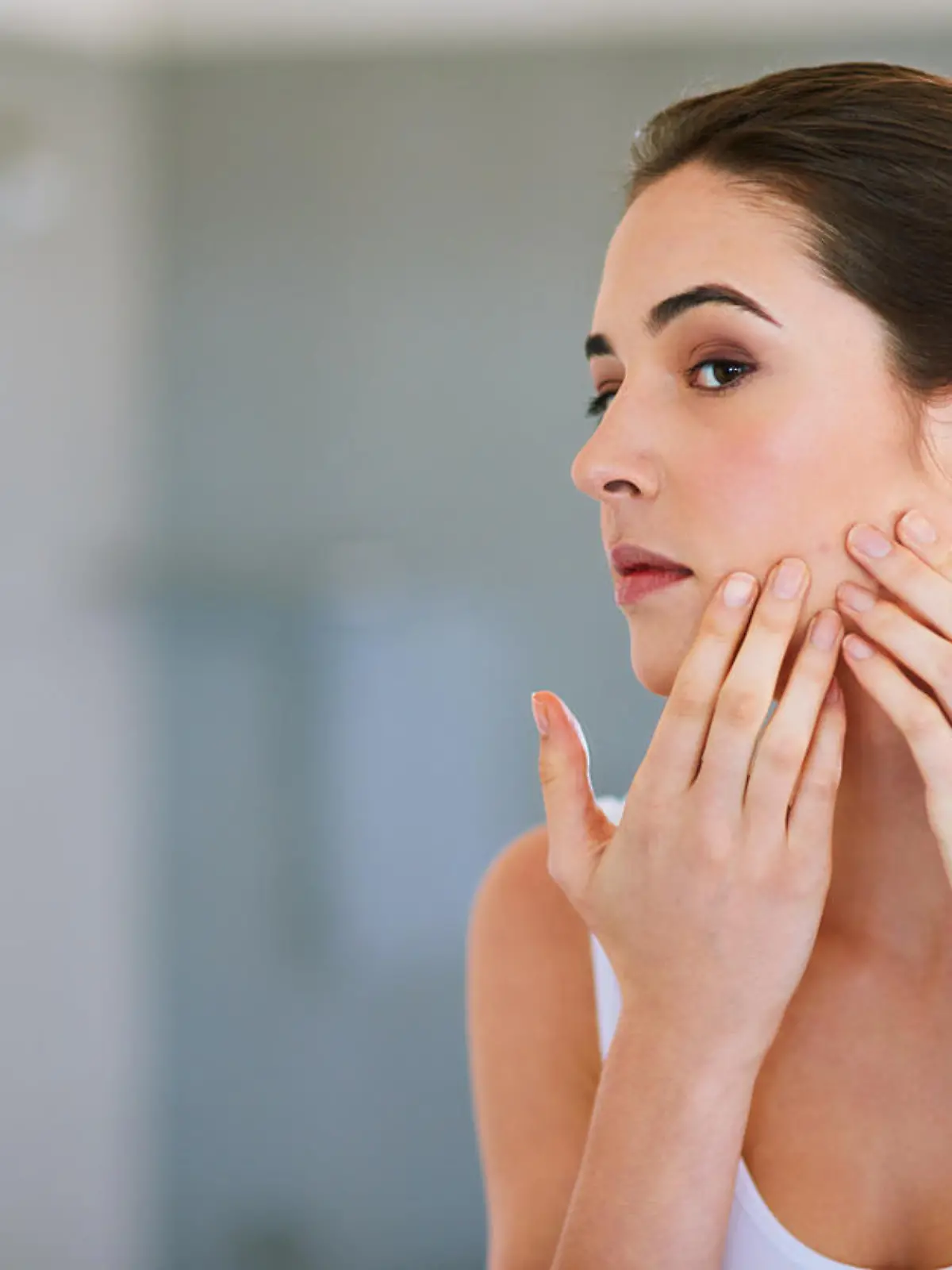 Cropped shot of a young woman squeezing a pimple on her face
