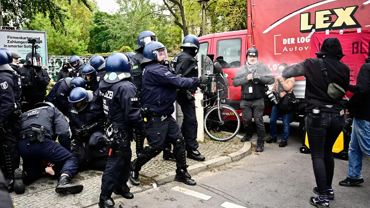 dpatopbilder - 15.10.2021, Berlin: Ein Polizist sprüht während einer Verhaftung eines Demonstranten am Rande der Räumung der Bauwagensiedlung Pfefferspray. Die sogenannte Wagenburg «Köpi» gilt seit vielen Jahren als eines der Symbolprojekte der linksradikalen Szene in Berlin. Foto: Fabian Sommer/dpa +++ dpa-Bildfunk +++