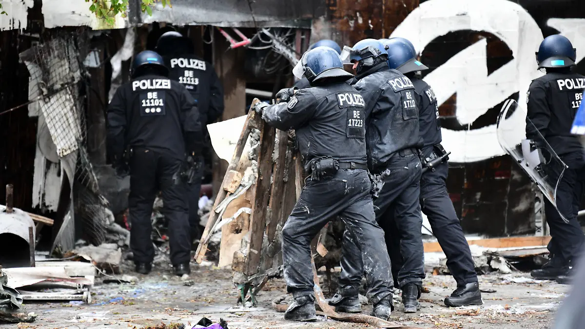 15.10.2021, Berlin: Polizisten räumen Barrikaden am Eingang der Bauwagensiedlung während der Räumung aus dem Weg. Die sogenannte Wagenburg «Köpi» gilt seit vielen Jahren als eines der Symbolprojekte der linksradikalen Szene in Berlin. Foto: Fabian Sommer/dpa +++ dpa-Bildfunk +++