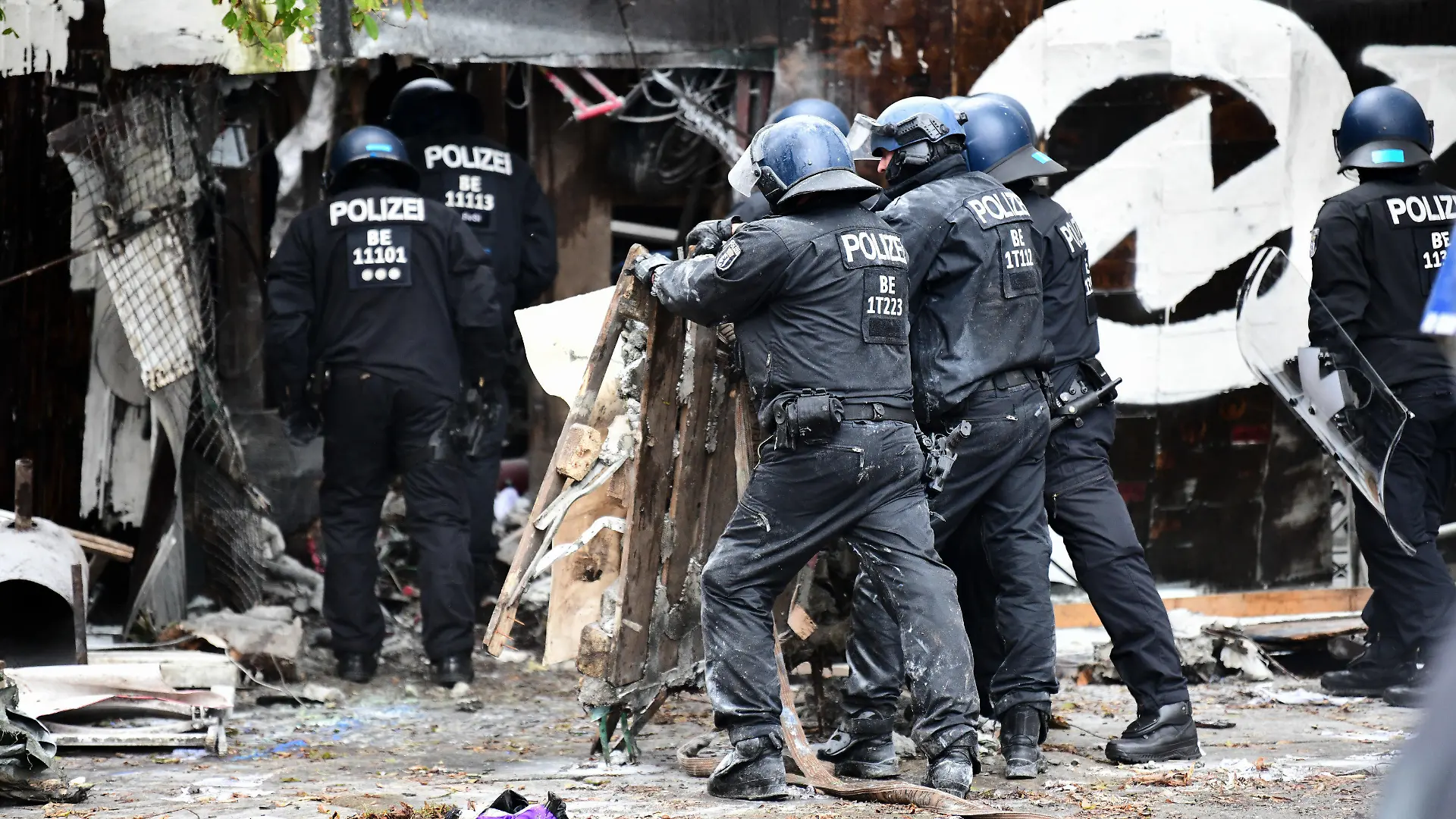 15.10.2021, Berlin: Polizisten räumen Barrikaden am Eingang der Bauwagensiedlung während der Räumung aus dem Weg. Die sogenannte Wagenburg «Köpi» gilt seit vielen Jahren als eines der Symbolprojekte der linksradikalen Szene in Berlin. Foto: Fabian Sommer/dpa +++ dpa-Bildfunk +++
