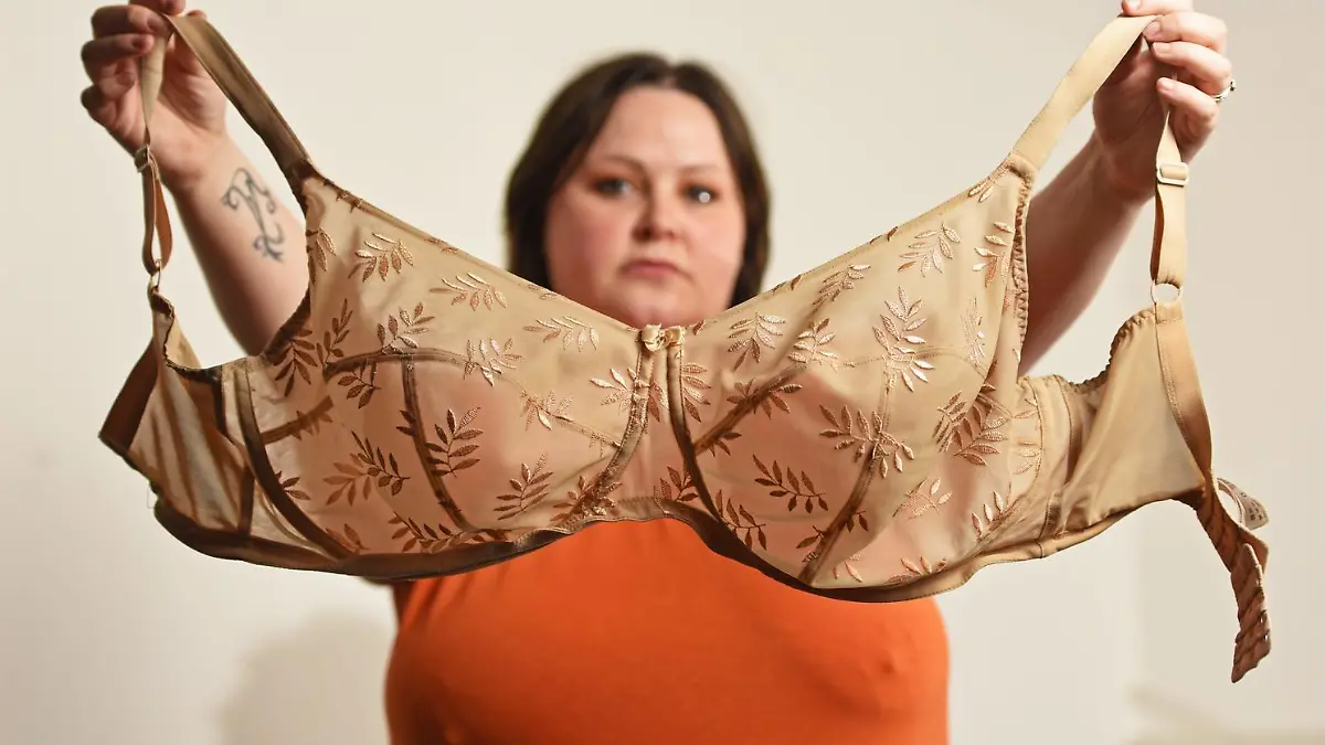 WILLIAM LAILEY / CATERS NEWS (PICTURED- Elizabeth Catlin holding up the one and only bra she owns) - A mum with ever-growing 34JJ breasts has stated that she couldn't even breastfeed her own daughter in fear she'd suffocate her. Elizabeth Catlin, from Swadlincote, Derbs, says that since the age of 10 her boobs haven't stopped growing. She says this meant that she couldn't even breastfeed her daughter, Willow, now two, as they would have covered her face and suffocated her. The 32-year-old is now a JJ in cup size and desperate for breast reduction surgery because she hates her boobs so much. - SEE CATERS COPY