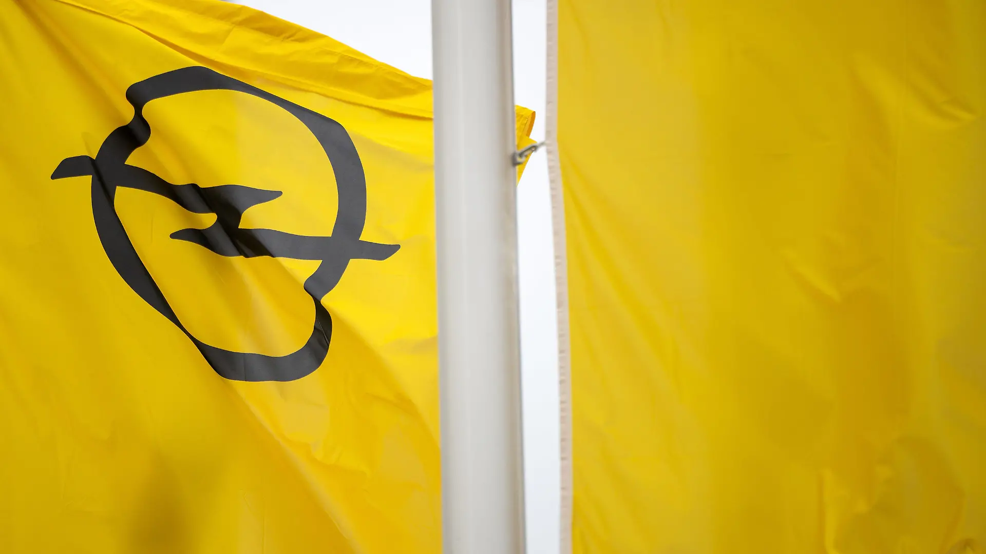 ARCHIV - 17.03.2020, Thüringen, Eisenach: Eine Fahne mit dem Opel-Logo weht bei Opelwerk Eisenach. Der Autobauer Stellantis erwägt, seiner deutschen Tochter Opel die Verantwortung über die Werke in Eisenach und Rüsselsheim zu entziehen. Foto: Michael Reichel/dpa +++ dpa-Bildfunk +++