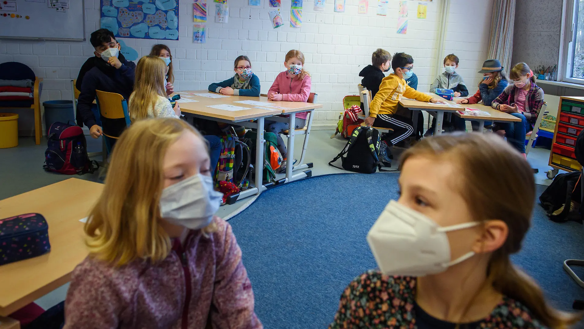22.02.2021, Schleswig-Holstein, Kiel: Schüler und Schülerinnen einer 4. Klasse sitzen im Unterricht an der Grundschule Russee in Kiel zusammen an einem Tisch und tragen dabei einen Mund-Nasen-Schutz. Trotz weiterhin verschärfter Kontaktbeschränkungen für die Bevölkerung in der Coronakrise sollen in Schleswig-Holstein ab heute Grundschüler und Kindergartenkinder wie die jeweiligen Einrichtungen besuchen. Foto: Gregor Fischer/dpa +++ dpa-Bildfunk +++