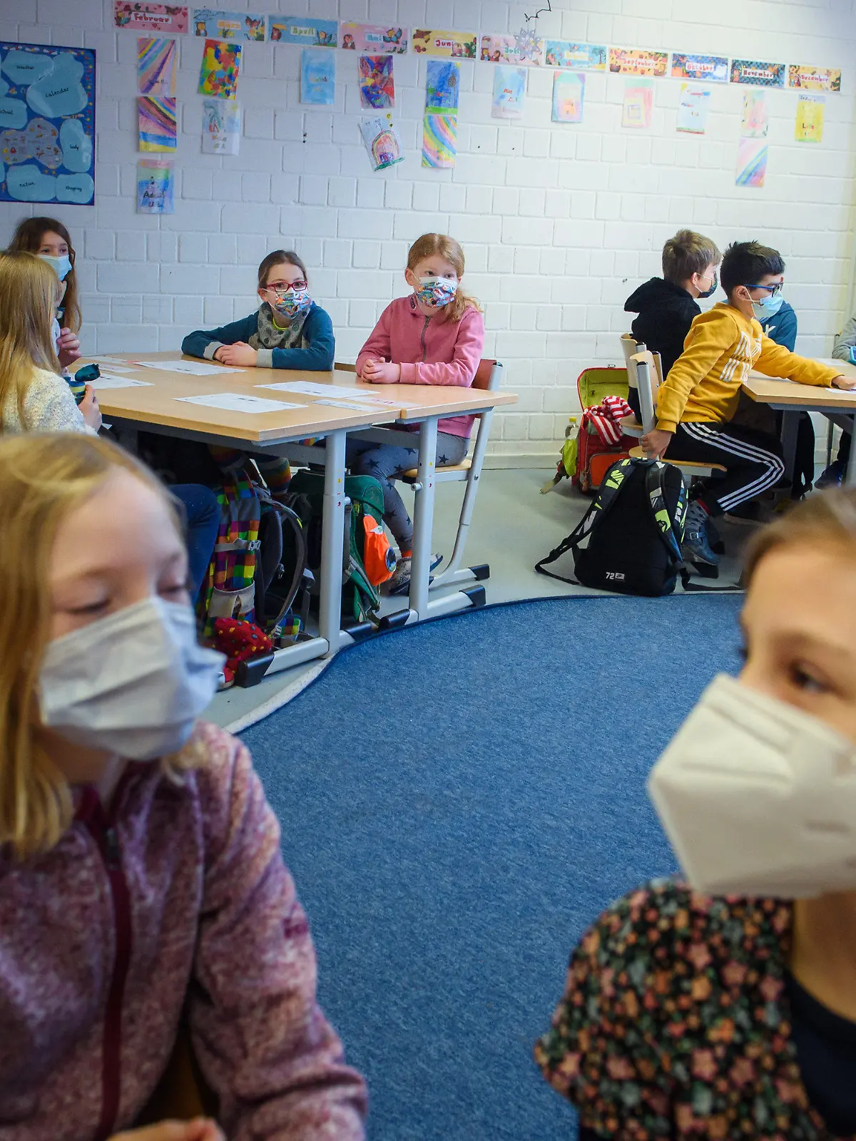 22.02.2021, Schleswig-Holstein, Kiel: Schüler und Schülerinnen einer 4. Klasse sitzen im Unterricht an der Grundschule Russee in Kiel zusammen an einem Tisch und tragen dabei einen Mund-Nasen-Schutz. Trotz weiterhin verschärfter Kontaktbeschränkungen für die Bevölkerung in der Coronakrise sollen in Schleswig-Holstein ab heute Grundschüler und Kindergartenkinder wie die jeweiligen Einrichtungen besuchen. Foto: Gregor Fischer/dpa +++ dpa-Bildfunk +++