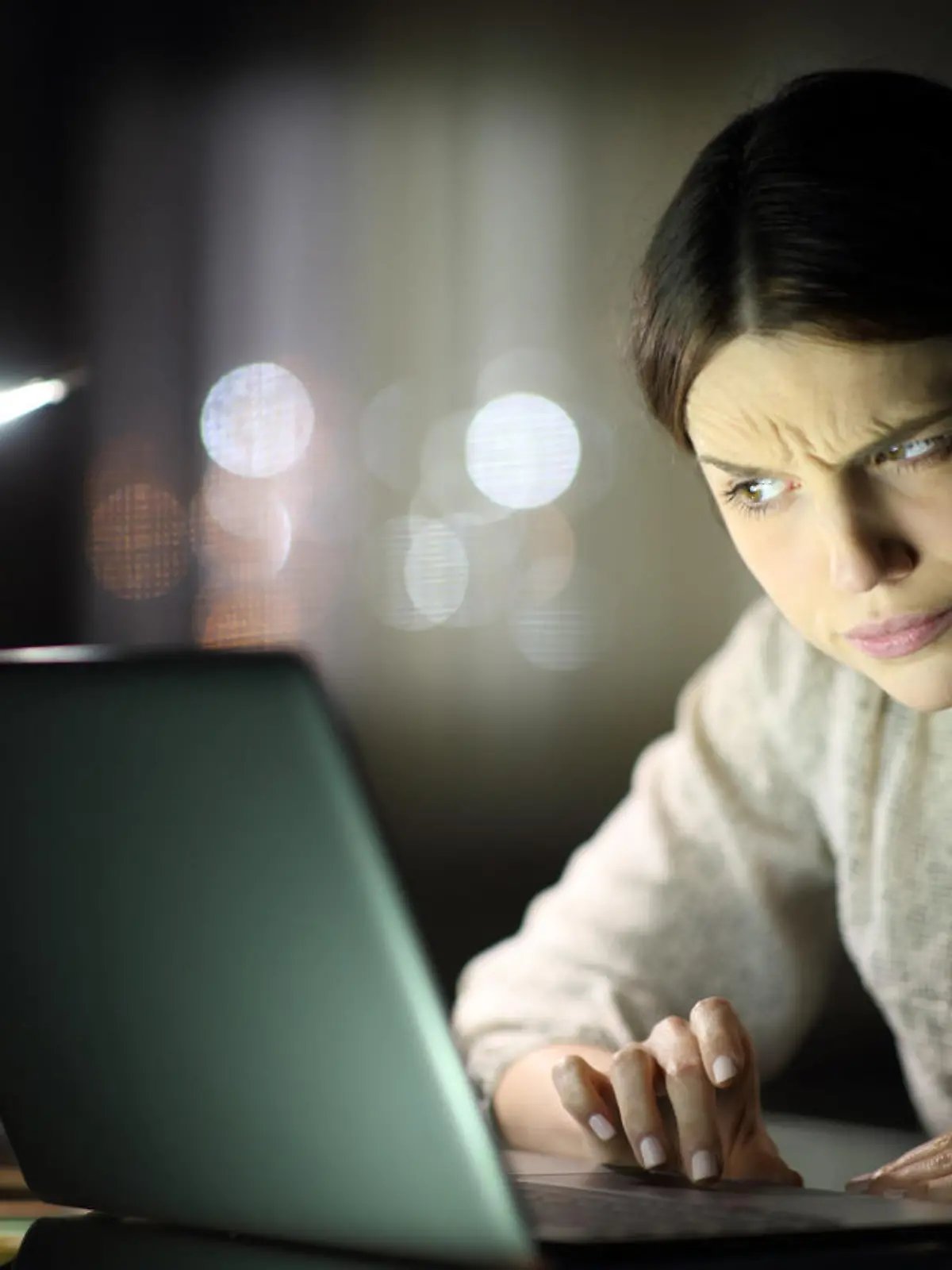 Suspicious woman checking laptop content in the night