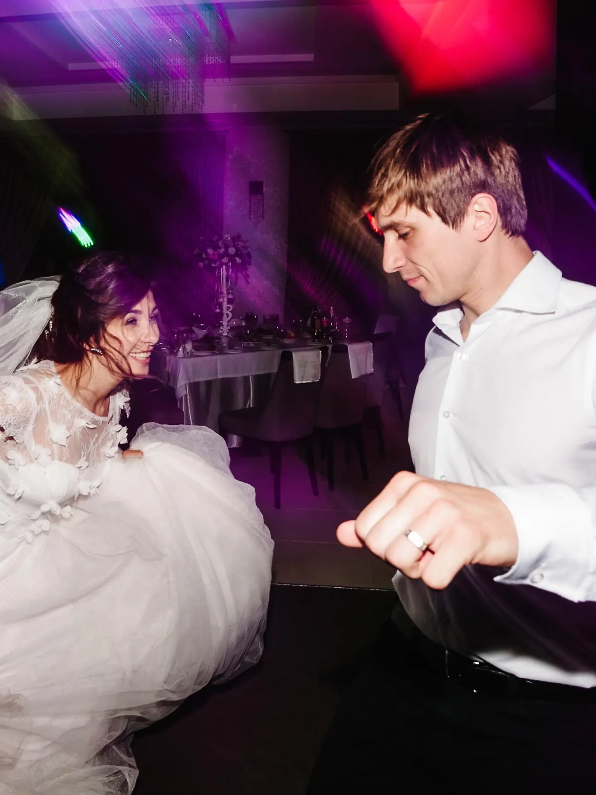 Wedding dance of newlywed and people. bride and groom dancing in restaurant. Wedding couple dancing in smoke and colored lights.