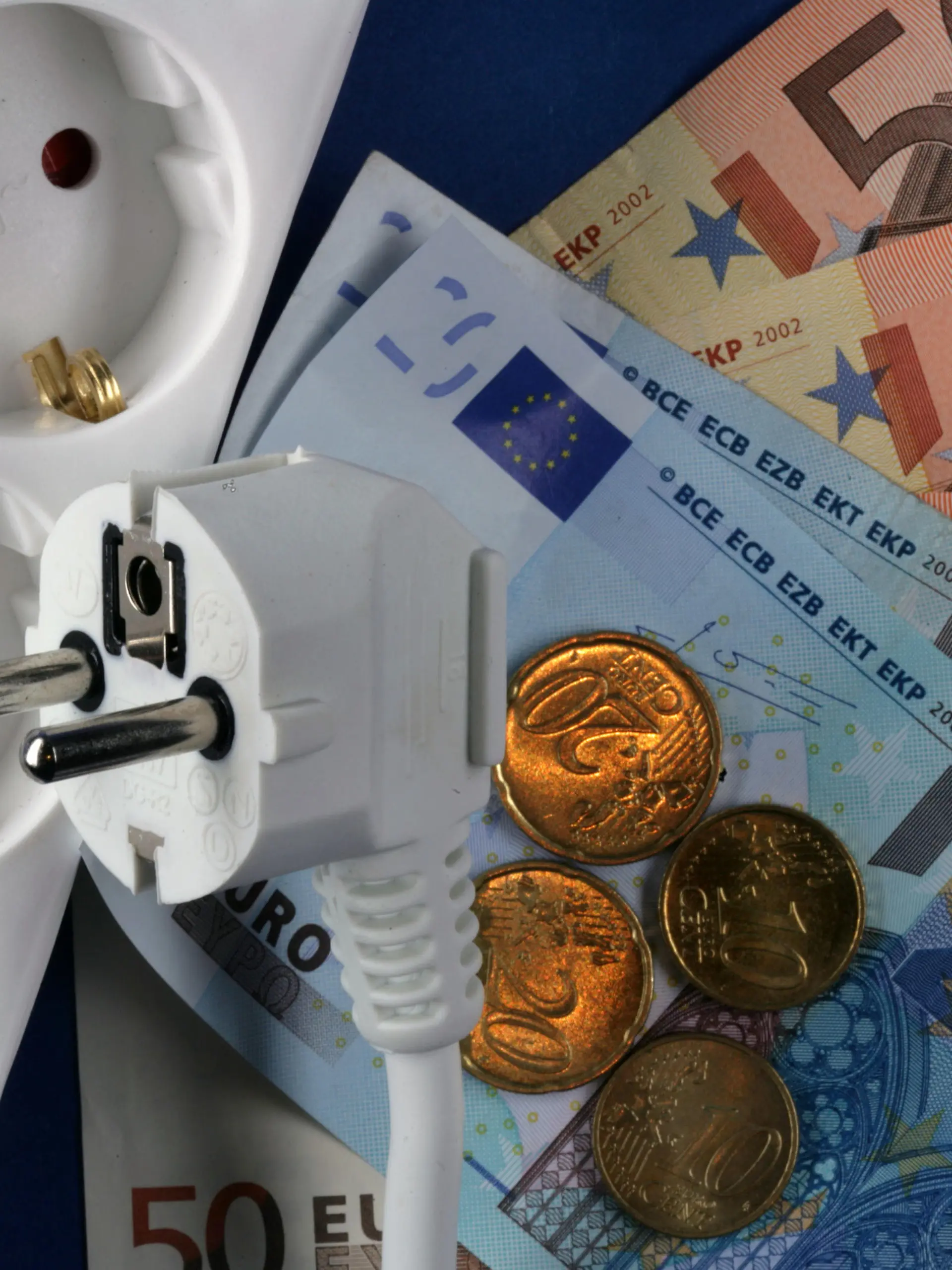 Euro-Geldscheine liegen neben einem Elektrostecker und einer Steckdosenleiste (Illustration zum Thema Strompreise), aufgenommen am 04.10.2006 in Schwerin. Der Strom-Preis für eine Kilowattstunde ist in den vergangenen acht Jahren um 2,35 Cent gestiegen. Zugleich ist der Preis für Erzeugung, Transport und Vertrieb des Stroms um einen Cent gefallen. Dies hat die Bundesregierung kürzlich in einer Antwort auf eine kleine Anfrage der Linksfraktion mitgeteilt. Auf dem Energiegipfel am Montag (09.10.2006), bei dem Bundeskanzlerin Merkel mit den Branchenvertretern über internationale und europäische Aspekte der Energieversorgung sprechen will, könnte auch das Thema Strompreise eine Rolle spielen. Foto: Jens Büttner +++(c) dpa - Report+++