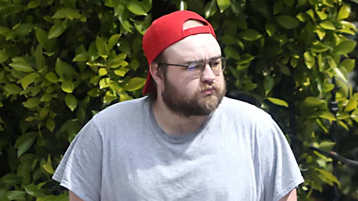 Exclusif - Prix Spécial - Premières photos depuis un an d'Angus T.Jones ("Mon Oncle Charlie"), méconnaissable et pieds nus dans son quartier de Los Angeles, le 21 mai 2023. L'enfant star gagnait pas moins de 350.000 dollars par épisode pour sa participation aux dix premières saisons de la série à succès. En 2012, profondément religieux, il a quitté le tournage malgré des apparitions dans les deux saisons suivantes. Depuis dix ans, il vit pratiquement reclus, disposant d'une fortune estimée à 20 millions de dollars. Sur ces photos, l'air hagard, barbu et presque chauve, le comédien de 29 ans déambule pieds nus. Exclusive - Special Price - Former child superstar Angus T Jones looks totally unrecognizable and virtually bald as he is seen for the first time in almost a year whilst shuffling around barefoot in his LA neighborhood. The Two And A Half Men alum, now 29, made his name as Jake Harper in the CBS sitcom alongside Charlie Sheen and Jon Cryer ? a role that paid $350,000 per episode and made him the highest paid Hollywood star of his generation. But he quit the series under a cloud in 2012 after rediscovering his Christian faith and dubbing the show ?filth? in an impassioned rant. He has become a major recluse in the decade that followed, hardly ever being seen and shunning the cameras whilst enjoying his $20 million fortune in relative obscurity. During his outing on May 21, 2023 Angus wore a back to front red baseball cap that covered his clearly balding scalp ? a far cry from the full head of hair he displayed when he was on TV. He also wore an oversized light gray T-shirt and shorts. In a separate set of images [also on this contact sheet] shot on April 30, 2023, Angus was also barefoot and wore similarly dressed-down attire. This time however he wore a black T-shirt, shorts and a green beanie hat. He has clearly trimmed his bushy beard back compared to the last time he was pictured prior to these sets ? in the early summer of 2022.