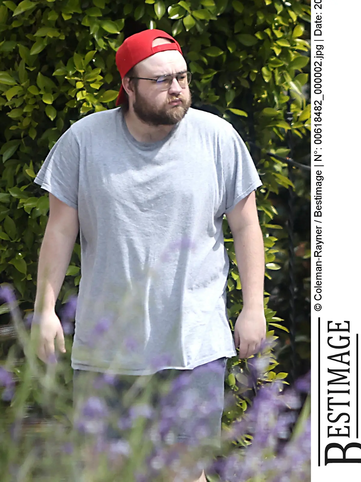 Exclusif - Prix Spécial - Premières photos depuis un an d'Angus T.Jones ("Mon Oncle Charlie"), méconnaissable et pieds nus dans son quartier de Los Angeles, le 21 mai 2023. L'enfant star gagnait pas moins de 350.000 dollars par épisode pour sa participation aux dix premières saisons de la série à succès. En 2012, profondément religieux, il a quitté le tournage malgré des apparitions dans les deux saisons suivantes. Depuis dix ans, il vit pratiquement reclus, disposant d'une fortune estimée à 20 millions de dollars. Sur ces photos, l'air hagard, barbu et presque chauve, le comédien de 29 ans déambule pieds nus. Exclusive - Special Price - Former child superstar Angus T Jones looks totally unrecognizable and virtually bald as he is seen for the first time in almost a year whilst shuffling around barefoot in his LA neighborhood. The Two And A Half Men alum, now 29, made his name as Jake Harper in the CBS sitcom alongside Charlie Sheen and Jon Cryer ? a role that paid $350,000 per episode and made him the highest paid Hollywood star of his generation. But he quit the series under a cloud in 2012 after rediscovering his Christian faith and dubbing the show ?filth? in an impassioned rant. He has become a major recluse in the decade that followed, hardly ever being seen and shunning the cameras whilst enjoying his $20 million fortune in relative obscurity. During his outing on May 21, 2023 Angus wore a back to front red baseball cap that covered his clearly balding scalp ? a far cry from the full head of hair he displayed when he was on TV. He also wore an oversized light gray T-shirt and shorts. In a separate set of images [also on this contact sheet] shot on April 30, 2023, Angus was also barefoot and wore similarly dressed-down attire. This time however he wore a black T-shirt, shorts and a green beanie hat. He has clearly trimmed his bushy beard back compared to the last time he was pictured prior to these sets ? in the early summer of 2022.