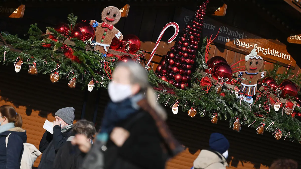 25.11.2020, Baden-Württemberg, Stuttgart: Passanten gehen an einem weihnachtlich geschmückten Stand in der Innenstadt vorbei. In der baden-württembergischen Landeshauptstadt findet aufgrund der Corona-Pandemie kein Weihnachtsmarkt statt. Vom 26. November bis 09. Januar 2021 werden als Alternative zum Weihnachtsmarkt im Rahmen der Veranstaltung «Adventszauber» 33 Stände ihre Waren zum Mitnehmen anbieten. Foto: Marijan Murat/dpa +++ dpa-Bildfunk +++
