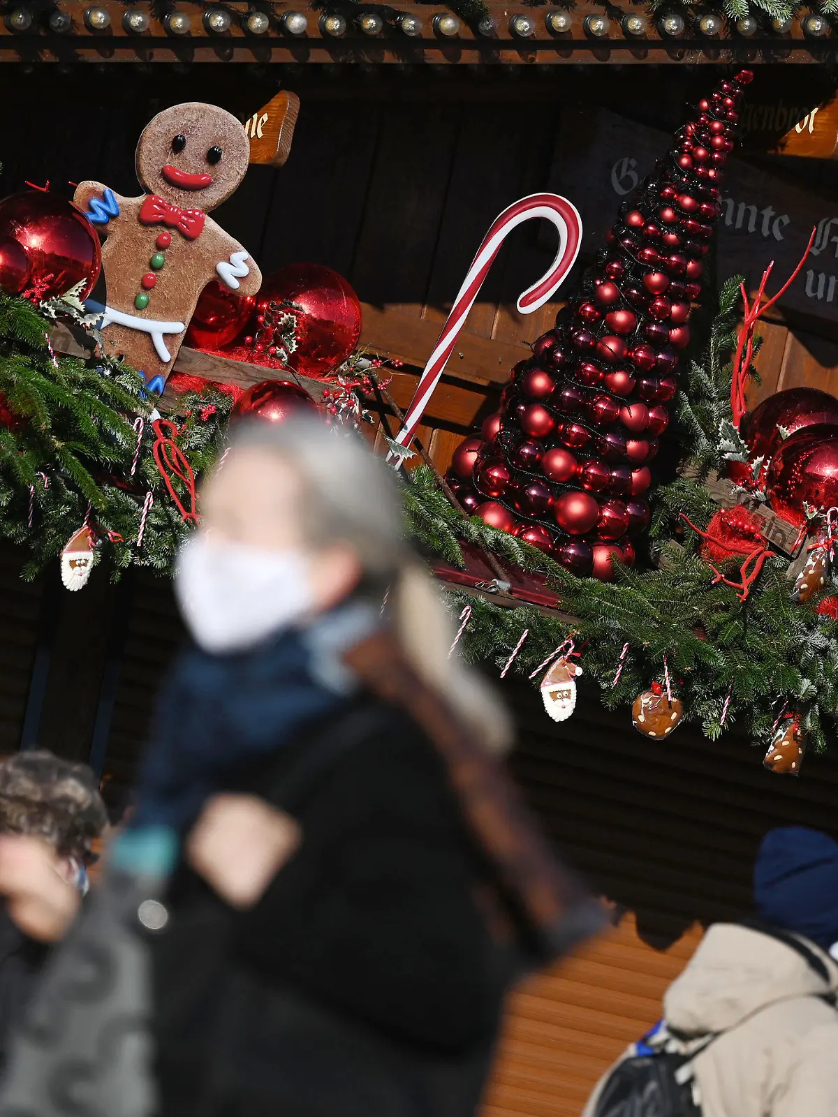 25.11.2020, Baden-Württemberg, Stuttgart: Passanten gehen an einem weihnachtlich geschmückten Stand in der Innenstadt vorbei. In der baden-württembergischen Landeshauptstadt findet aufgrund der Corona-Pandemie kein Weihnachtsmarkt statt. Vom 26. November bis 09. Januar 2021 werden als Alternative zum Weihnachtsmarkt im Rahmen der Veranstaltung «Adventszauber» 33 Stände ihre Waren zum Mitnehmen anbieten. Foto: Marijan Murat/dpa +++ dpa-Bildfunk +++