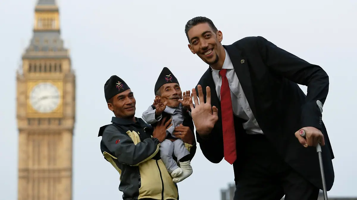 The world's shortest man Chandra Bahadur Dangi is held by nephew Dolakh Dangi as they pose with the tallest living man Sultan Kosen to mark the Guinness World Records Day in London November 13, 2014. Kosen measuring 251cm, towers over Dangi who is only 54.6cm tall. The Guinness World Records celebrates its 60th edition of the annual records book. REUTERS/Luke MacGregor (BRITAIN - Tags: SOCIETY)