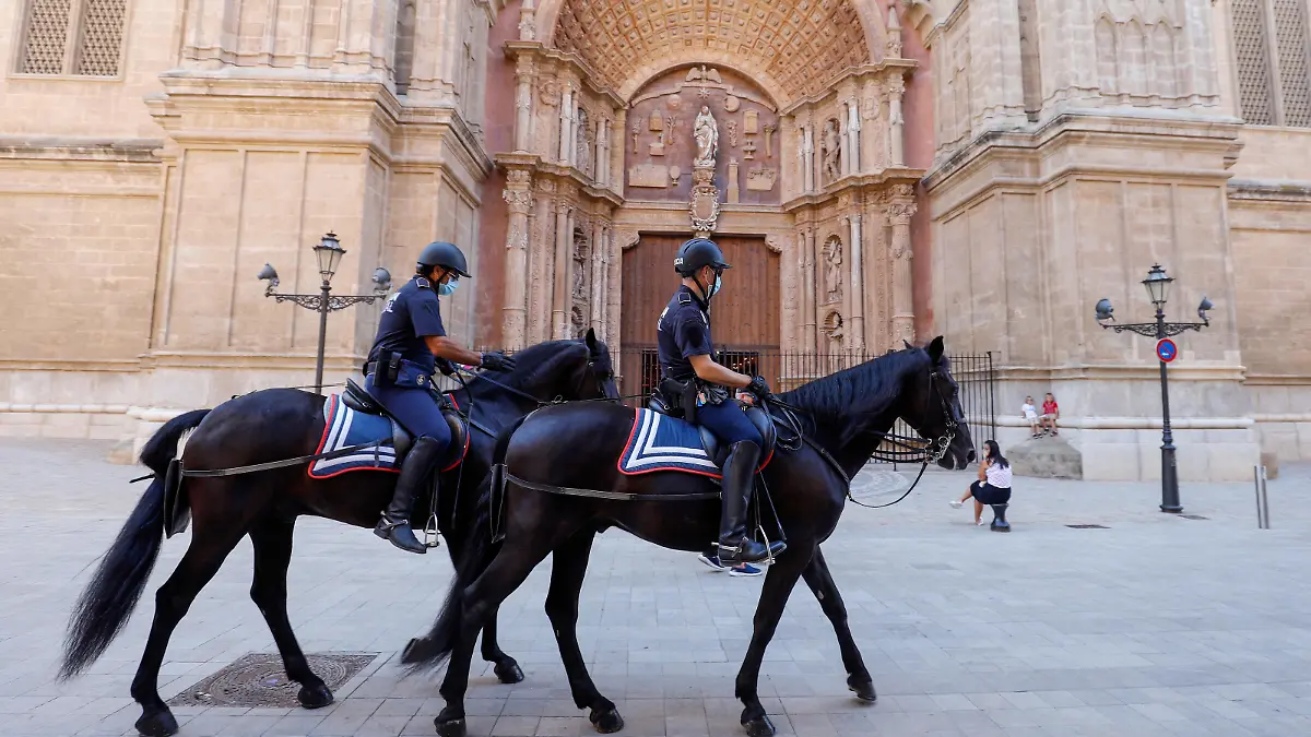 Berittene Polizisten reiten während ihrer Patrouille an der Kathedral vorbei. Urlauber, die aus dem Ausland nach Deutschland zurückkehren, können sich nach ihrer Rückkehr kostenlos auf das Virus testen lassen.
