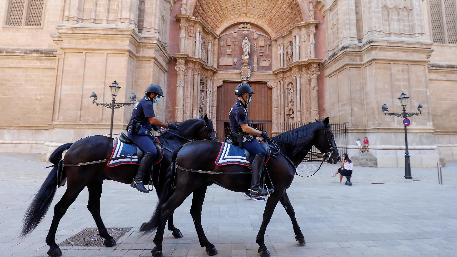 Berittene Polizisten reiten während ihrer Patrouille an der Kathedral vorbei. Urlauber, die aus dem Ausland nach Deutschland zurückkehren, können sich nach ihrer Rückkehr kostenlos auf das Virus testen lassen.