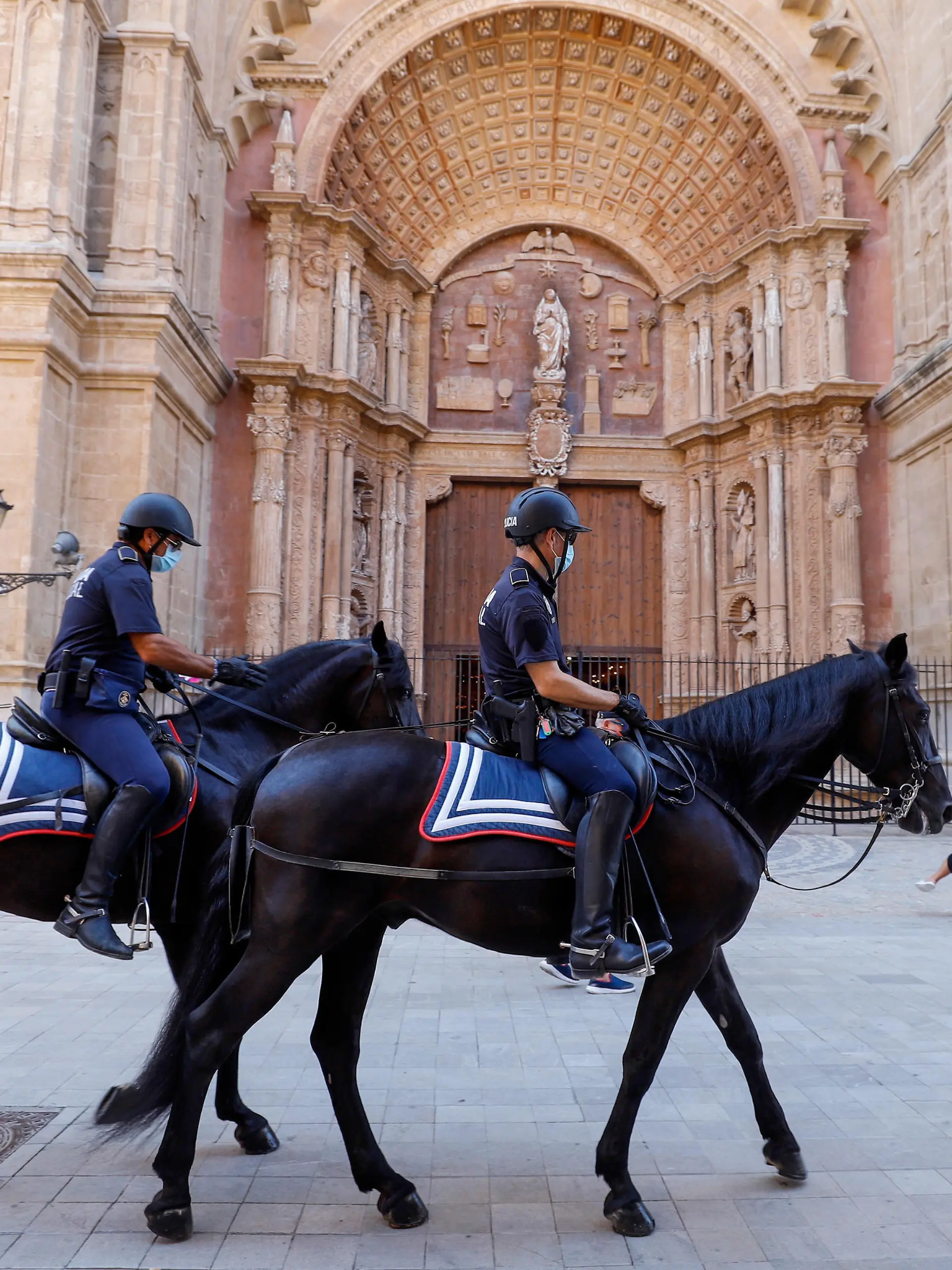 Berittene Polizisten reiten während ihrer Patrouille an der Kathedral vorbei. Urlauber, die aus dem Ausland nach Deutschland zurückkehren, können sich nach ihrer Rückkehr kostenlos auf das Virus testen lassen.