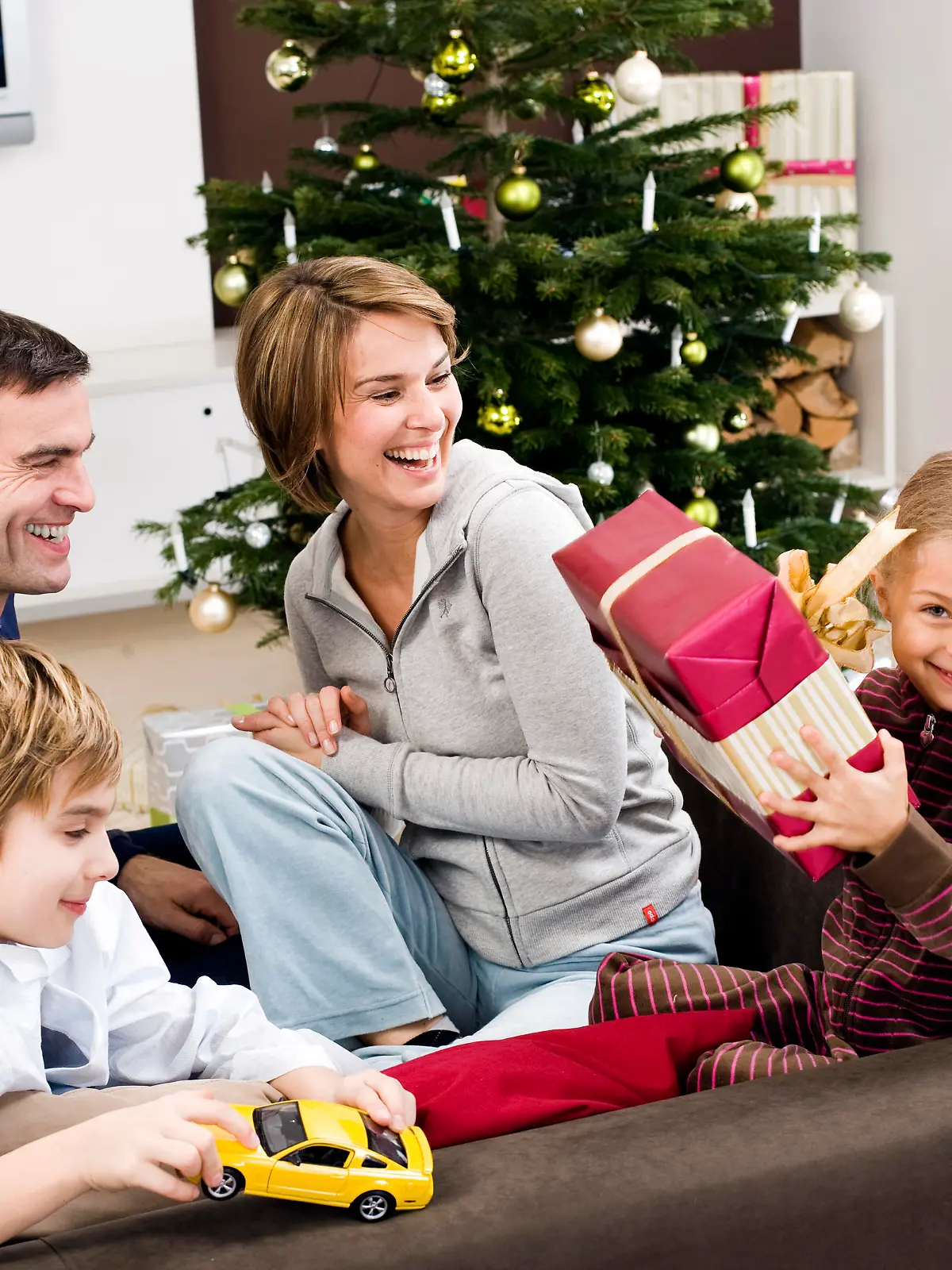 parents watching young girl holding present on christmas morning Keine Weitergabe an Drittverwerter., Royalty free: Bei werblicher Verwendung Preis auf Anfrage