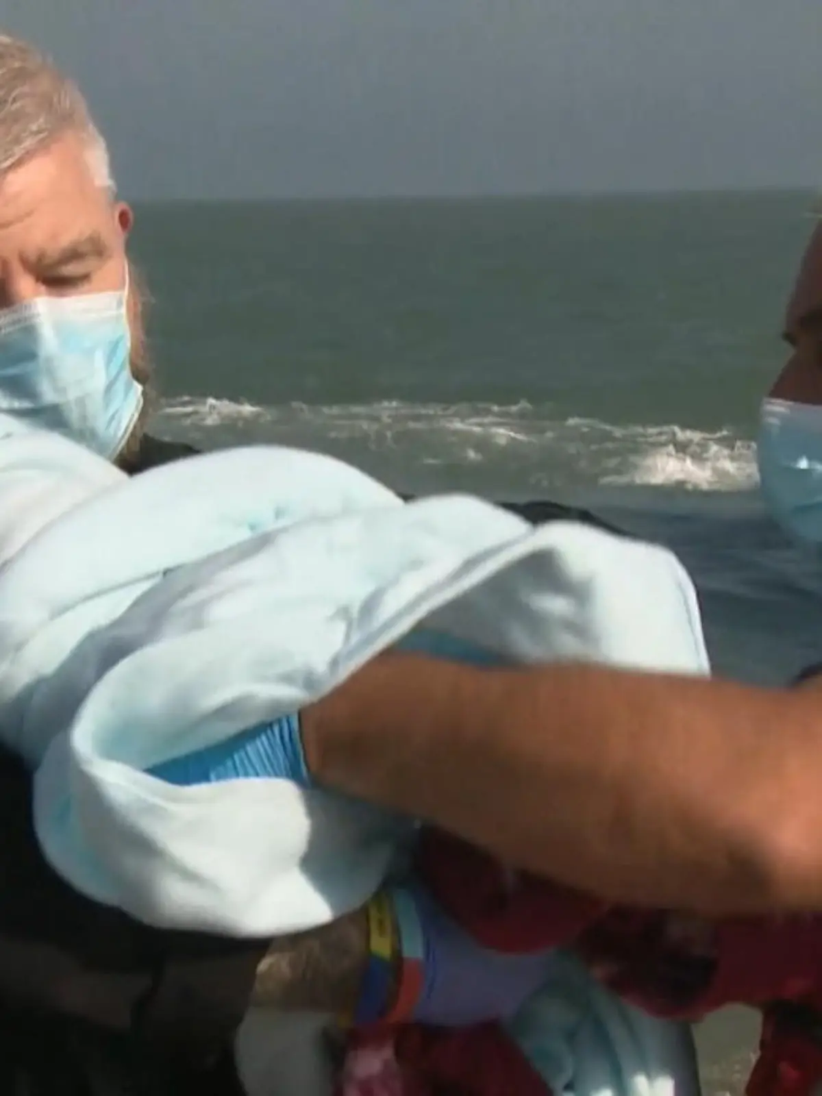 Eingewickelt in eine Decke wird sich vom Rettungsboot getragen: Die kleine Ayyan ist erst wenige Woche alt - und überlebte neun Tage auf dem offenen Meer. Ihre Mutter ist erleichtert, dass sie es über den Ärmelkanal geschafft haben.