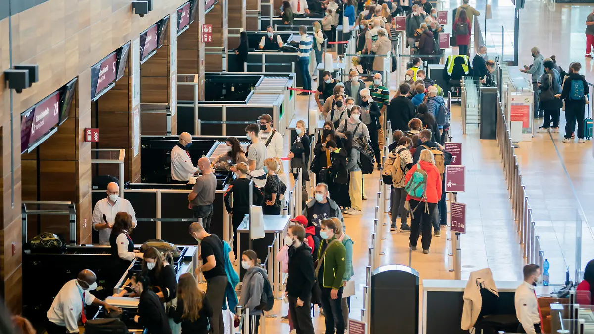 09.10.2021, Brandenburg, Schönefeld: Zahlreiche Passagiere stehen am Hauptstadtflughafen Berlin Brandenburg «Willy Brandt» (BER) im Terminal 1 vor der Sicherheitskontrolle Schlange. (Kein Ausschnitt) Foto: Christoph Soeder/dpa +++ dpa-Bildfunk +++