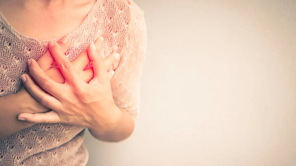 Frau mit Schmerzen in der Brust - Symptom einer Herzerkrankung