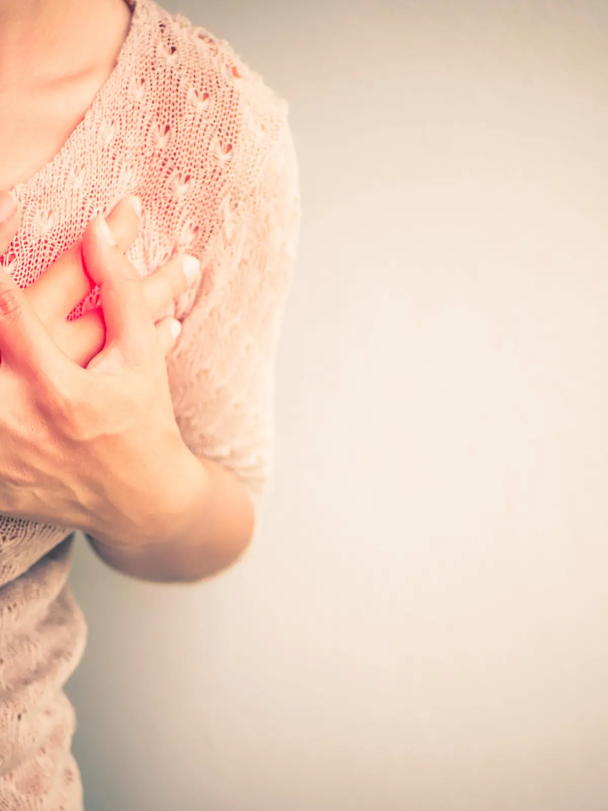 Frau mit Schmerzen in der Brust - Symptom einer Herzerkrankung