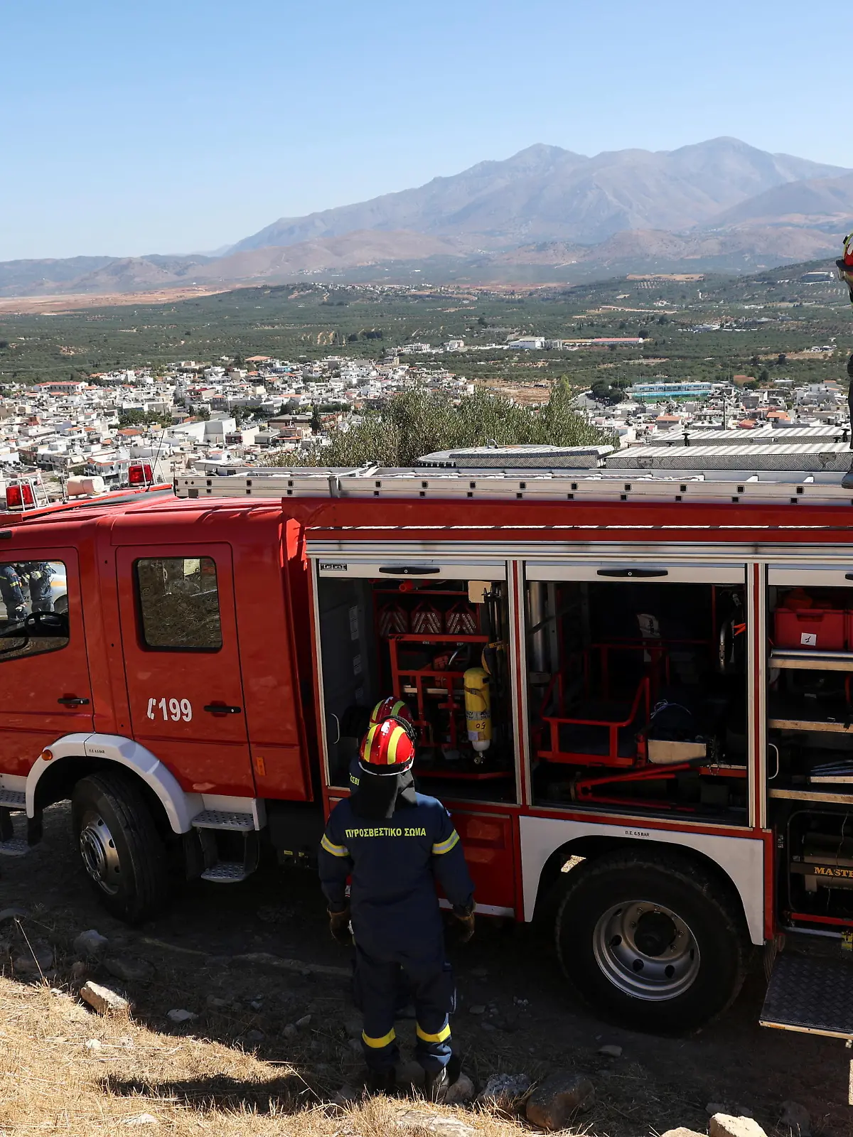 A firefighter stands on top of a fire engine following an earthquake, in the town of Arkalochori on the island of Crete, Greece, September 27, 2021. REUTERS/Stefanos Rapanis