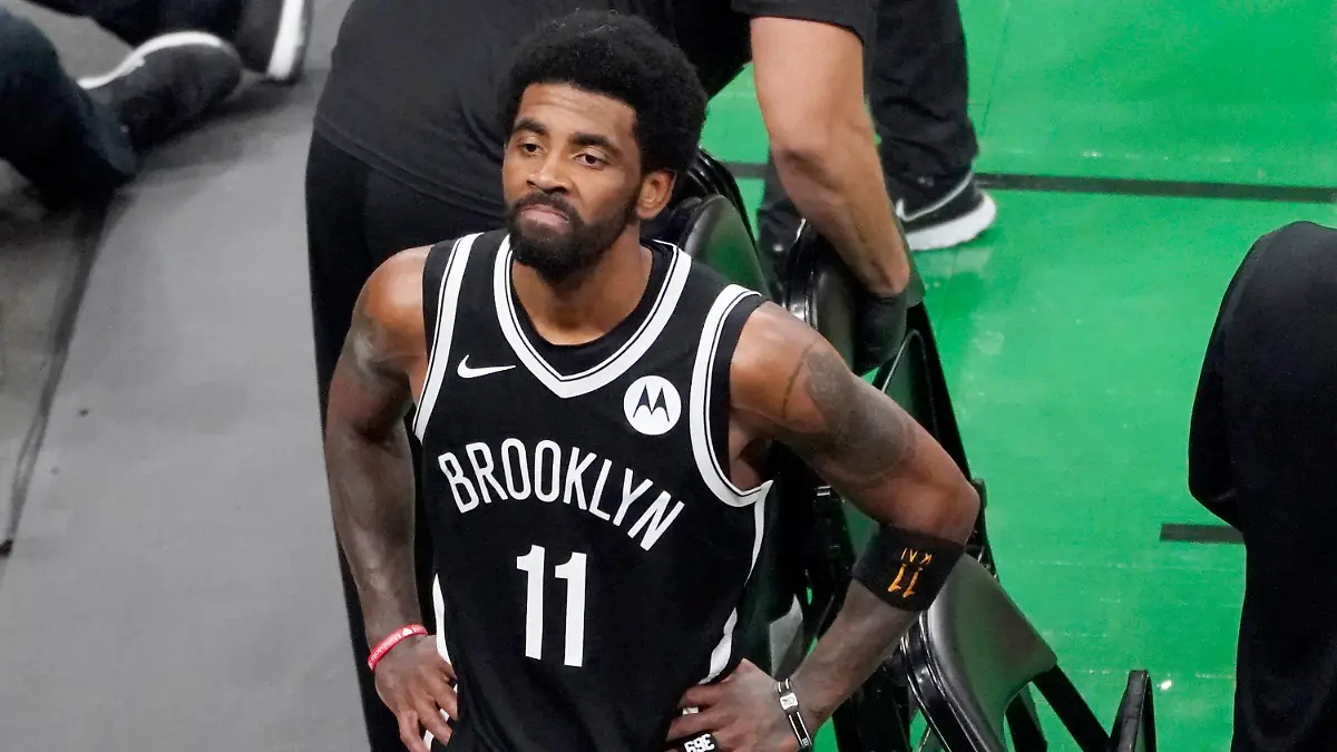 FILE - Brooklyn Nets guard Kyrie Irving looks up at the fans at TD Garden after they defeated the Boston Celtics in Game 4 during an NBA basketball first-round playoff series in Boston, in this Sunday, May 30, 2021, file photo. The Brooklyn Nets won't play Kyrie Irving until he can play in all their games, unwilling to let questions about his vaccination status linger into the season. The Nets announced Tuesday, Oct. 12, 2021, that Irving would not play or practice with them until he could be a full participant, ending the idea that he would play in only road games. Without mentioning his vaccination status, general manager Sean Marks said Irving has made a decision that keeps him from being able to perform with the team. (AP Photo/Elise Amendola, File)